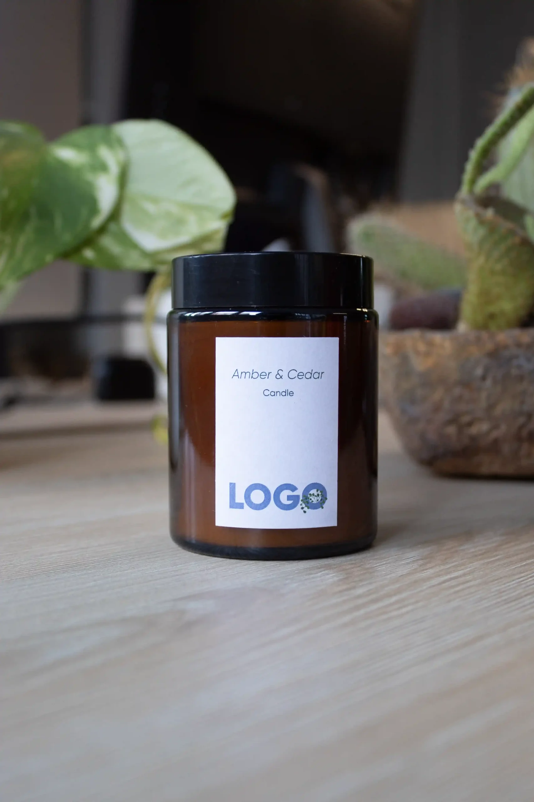 Vela ecológica en tarro de cristal con pegatina personalizada sobre una mesa de madera