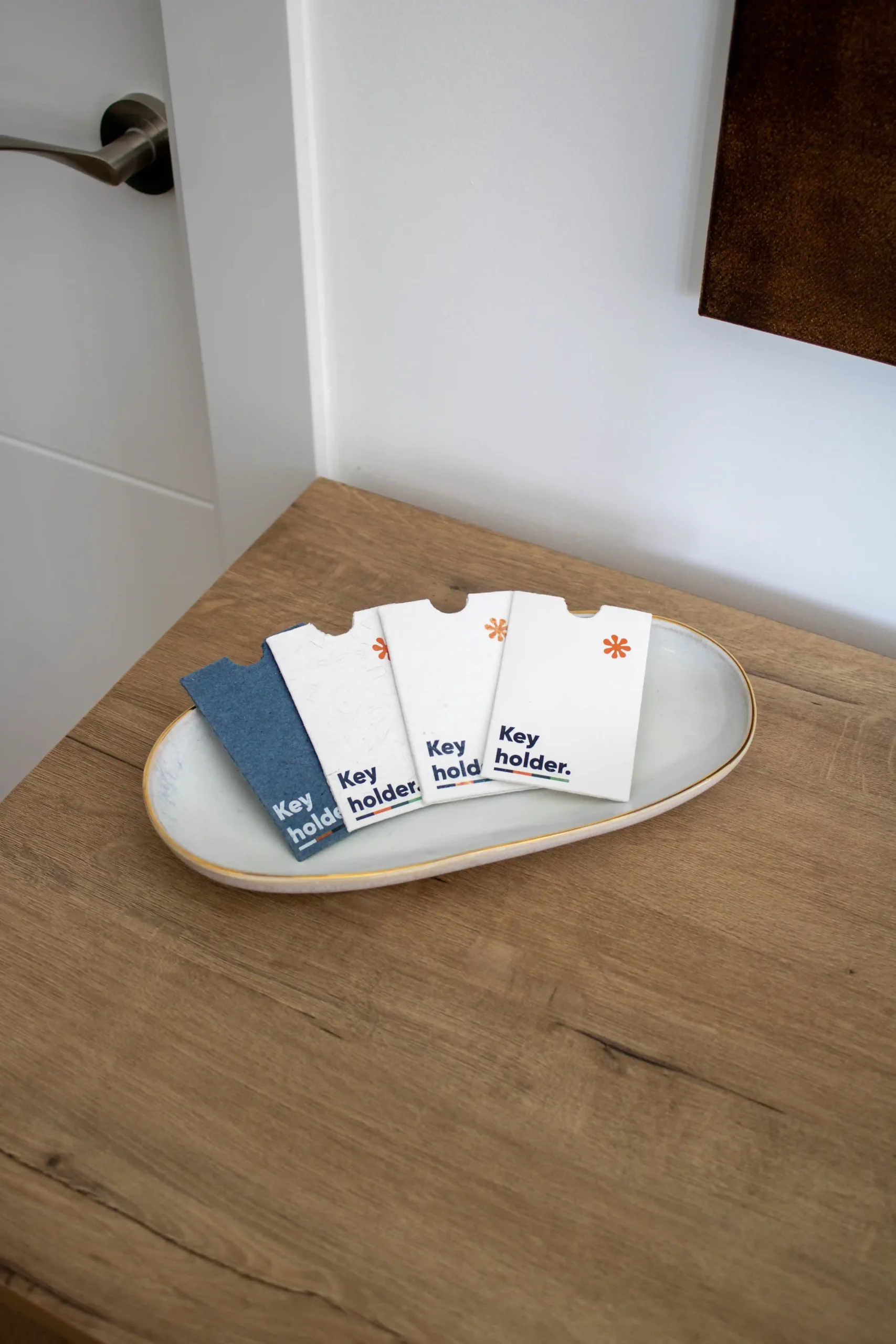 4 porta llaves de hotel personalizados colocados en una bandeja sobre una mesa de madera