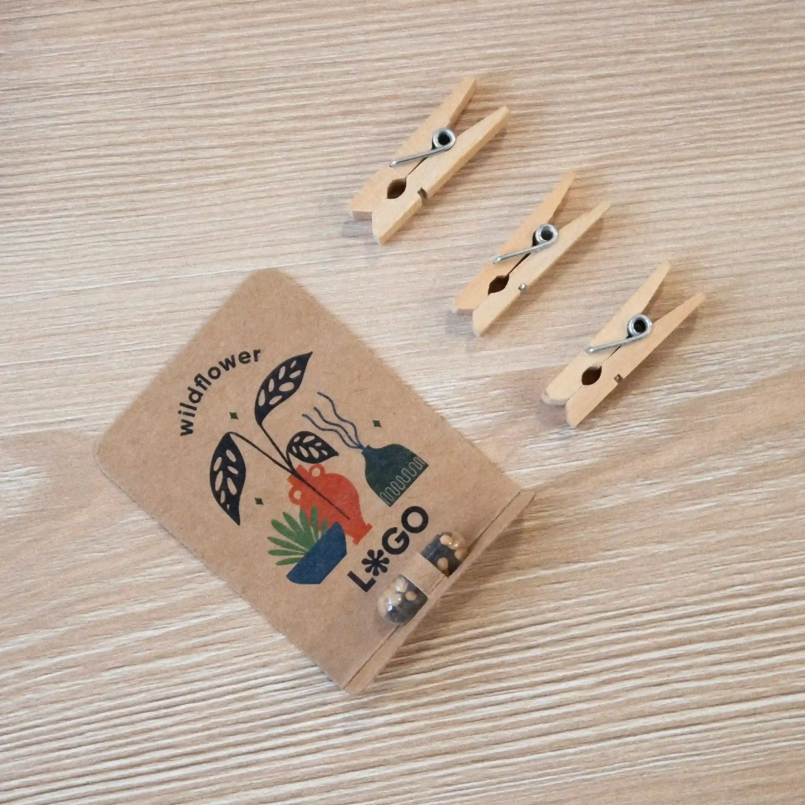 Cápsula biodegradable con semillas en su interior con packaging de cartón kraft personalizado sobre una mesa de madera