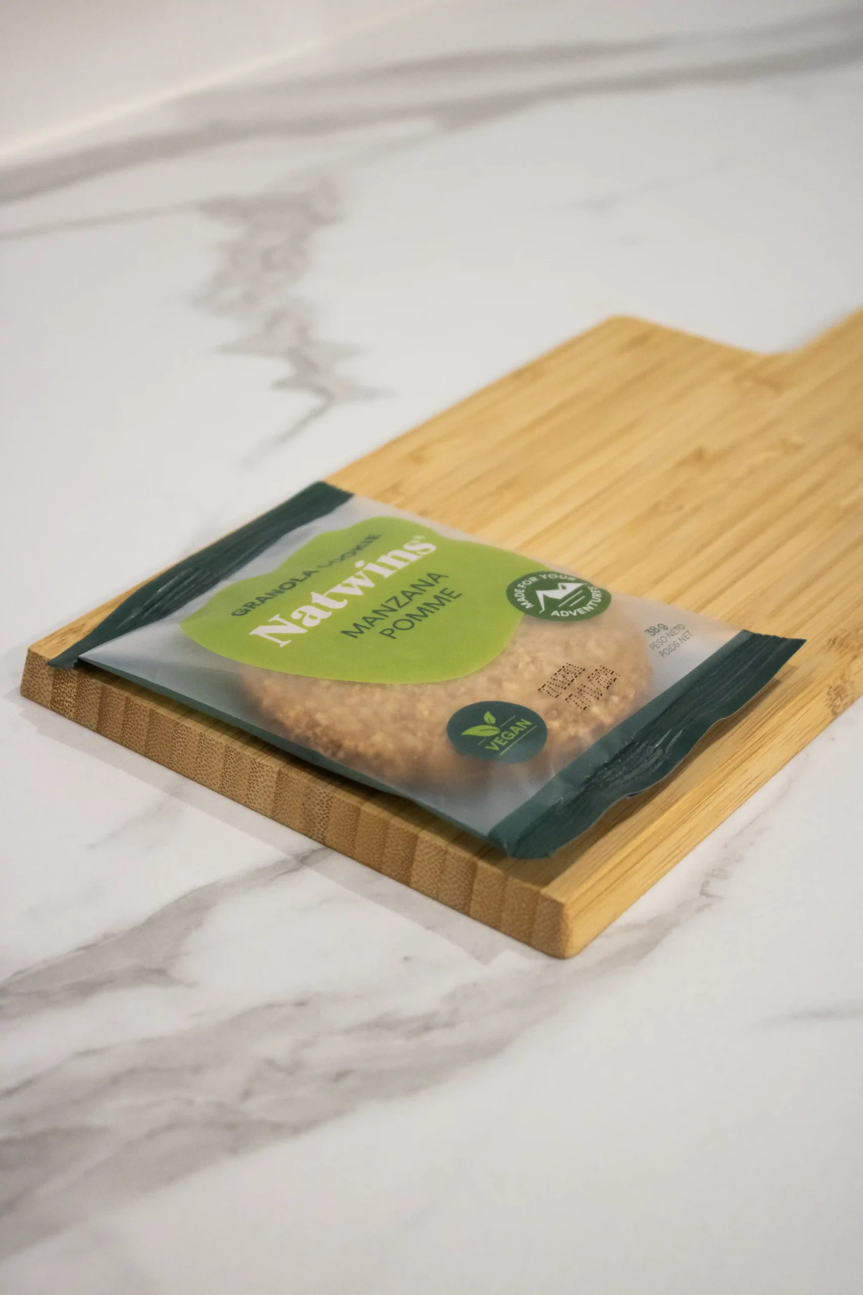 Galleta de granola de manzana de la marca Natwins sobre una tabla de madera de cocina