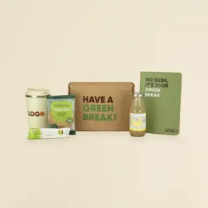 Taza take away beige, barrita de muesli, cookie de granola Natwins, botella de limonada Linda, cuaderno ecológico verde y caja de madera personalizada con el texto 'have a green break'
