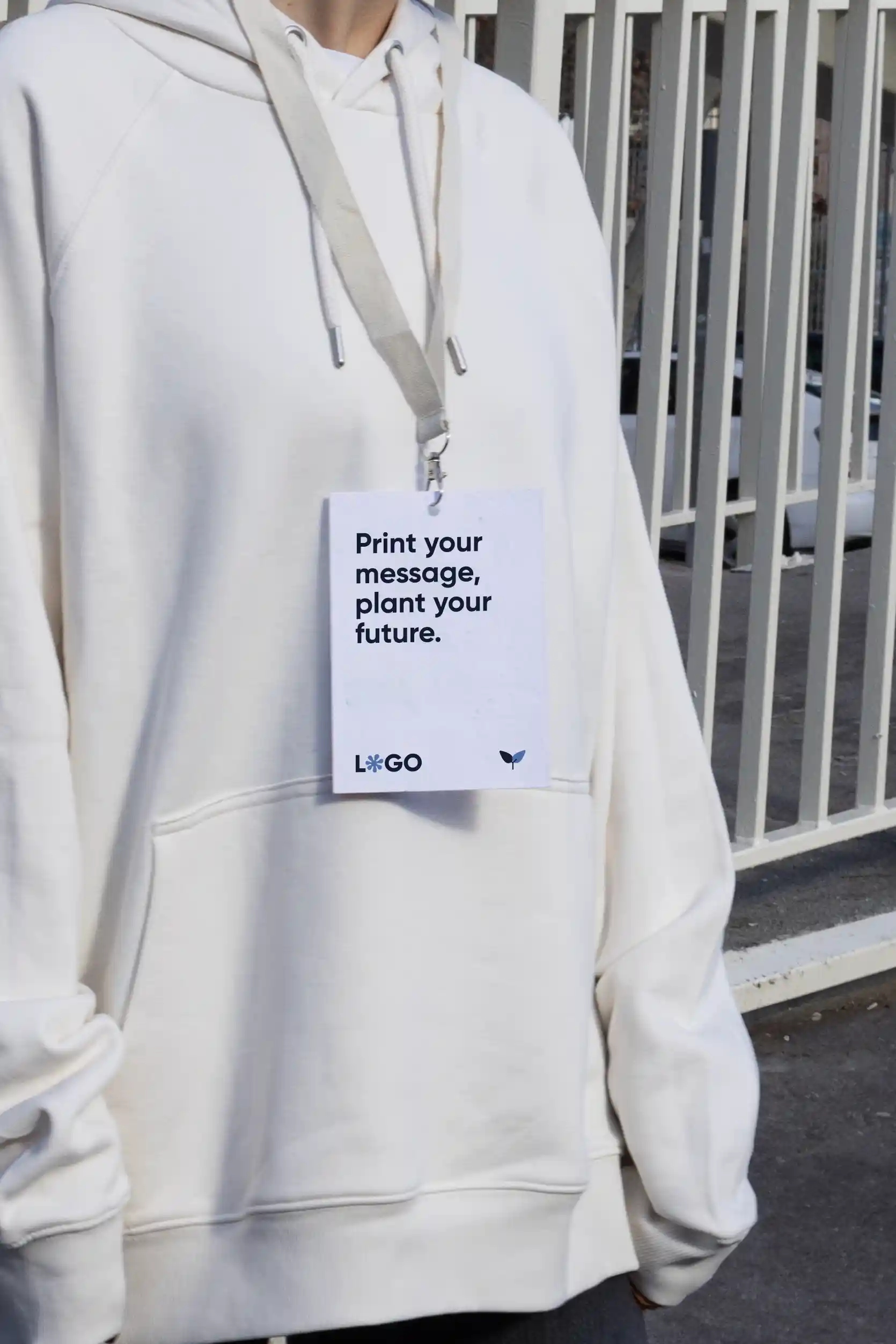 Chica con jersey blanco llevando al cuello una acreditación personalizada con lanyard de algodón