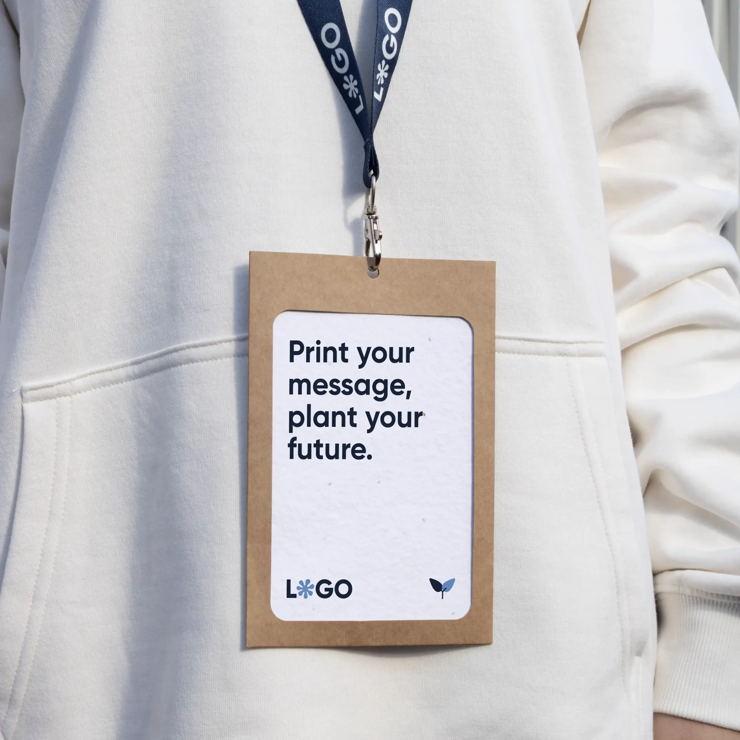 Acreditación personalizada con funda kraft y lanyard de rPET azul personalizado con el texto 'logo' en blanco colgado del cuello de una persona con jersey blanco