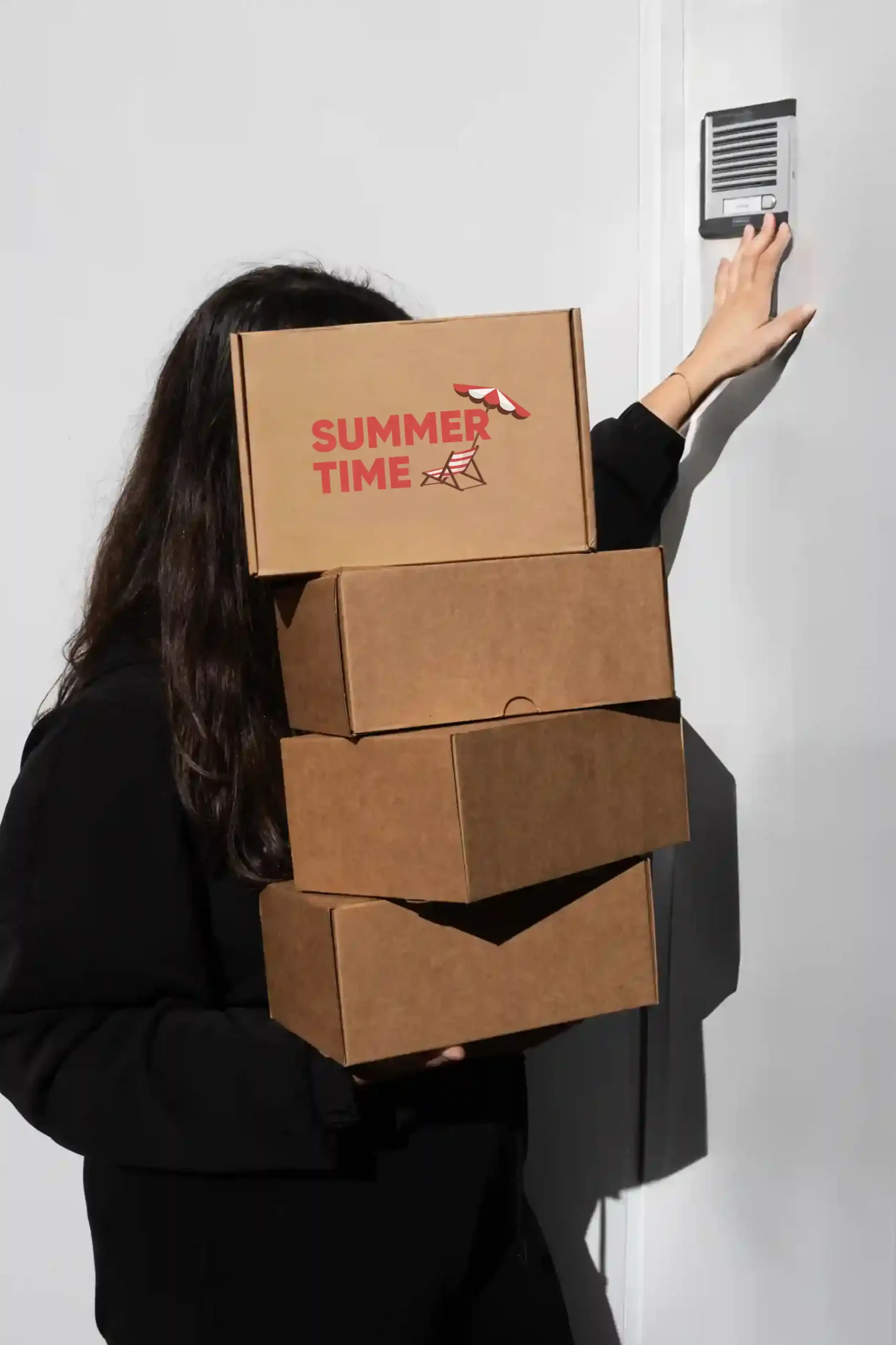 Chica cargando cajas de cartón personalizadas con el texto 'summer time' en rojo