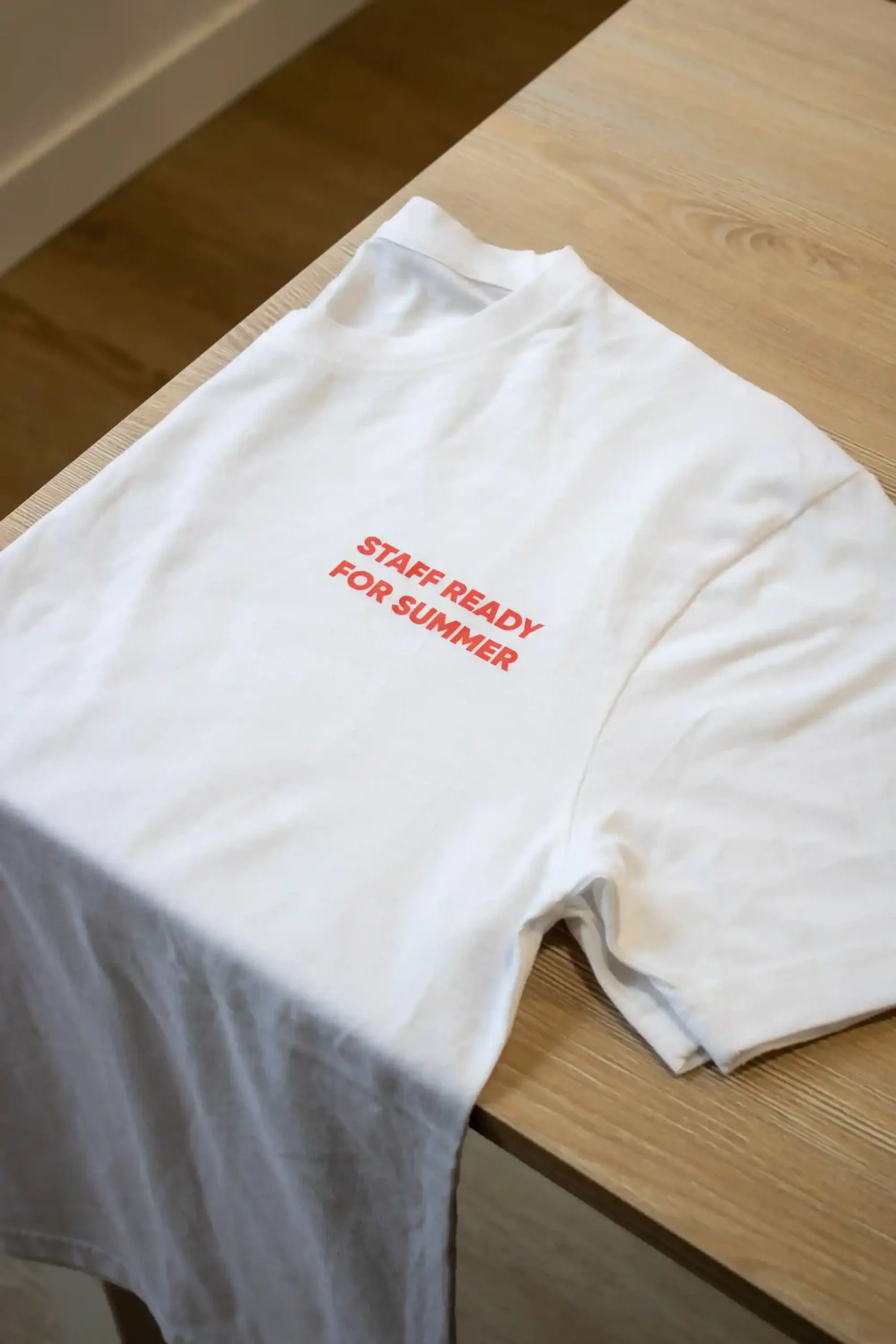 Camiseta blanca personalizada con texto 'Staff ready for summer' en rojo