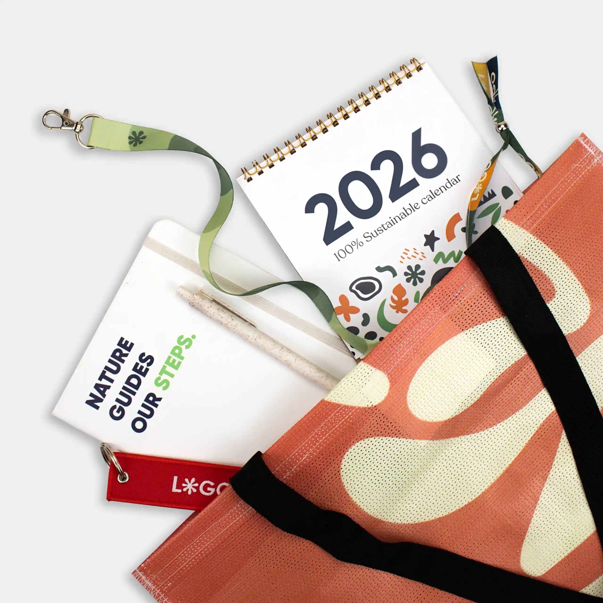 Selección de regalos personalizados para eventos: tote bag de lona, lanyard, cuaderno, calendario y llavero.