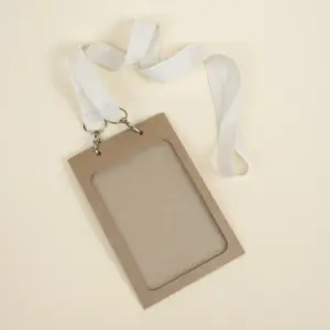 Funda de acreditación de cartón kraft marrón colgada de un lanyard de algodón blanco
