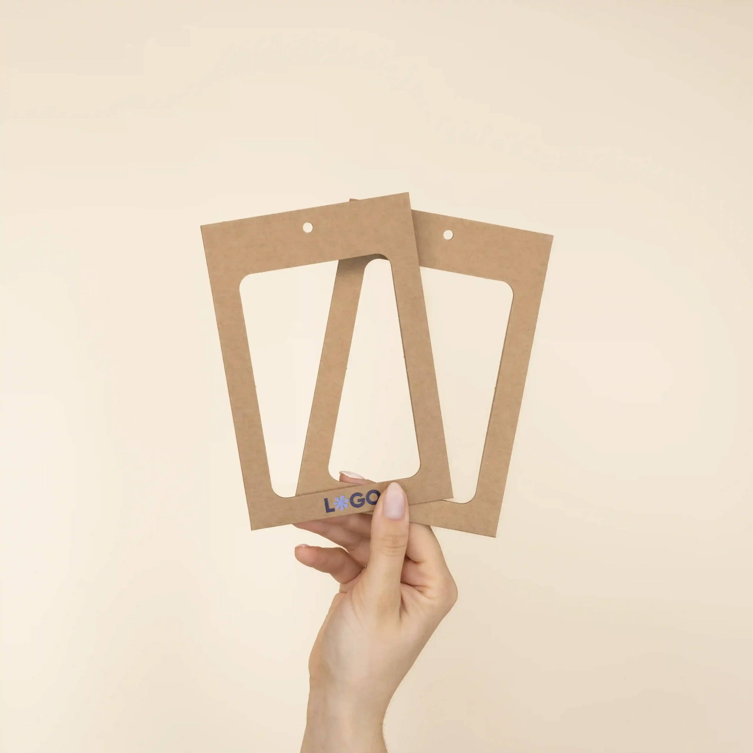 Mano mostrando dos fundas de acreditación en cartón kraft marrón