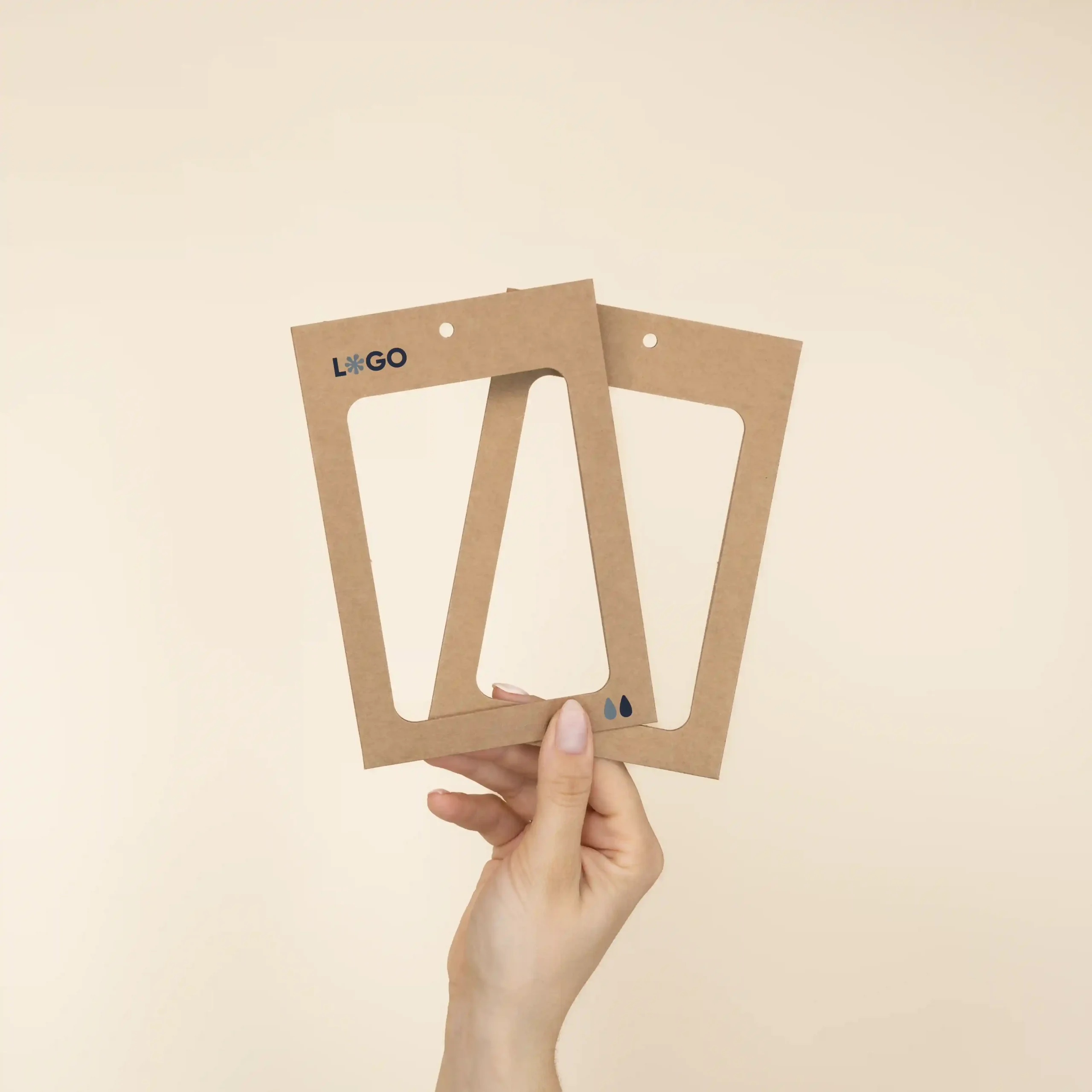 Mano mostrando dos fundas de acreditación personalizadas en cartón kraft marrón