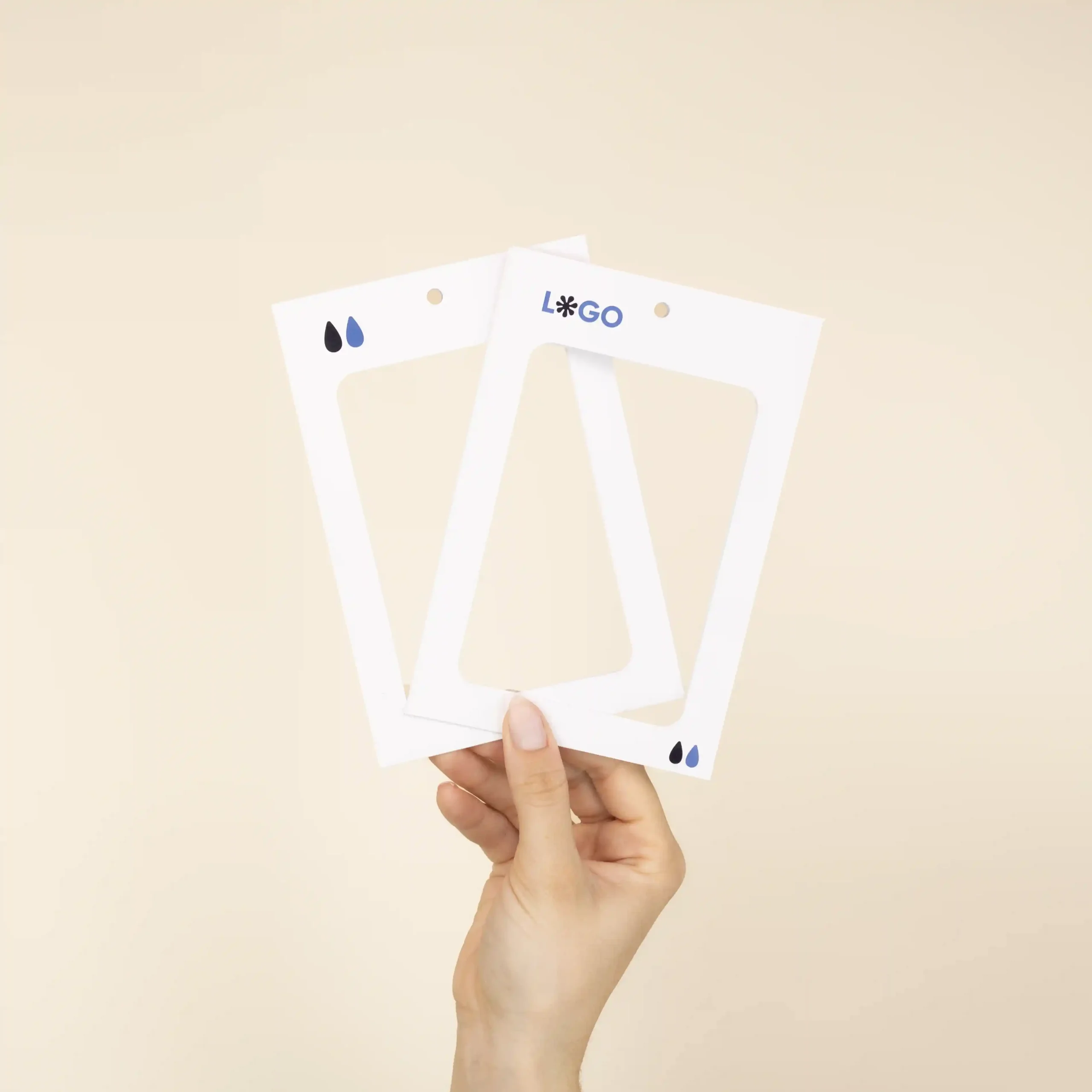 Mano mostrando dos fundas de acreditación personalizadas en cartón blanco