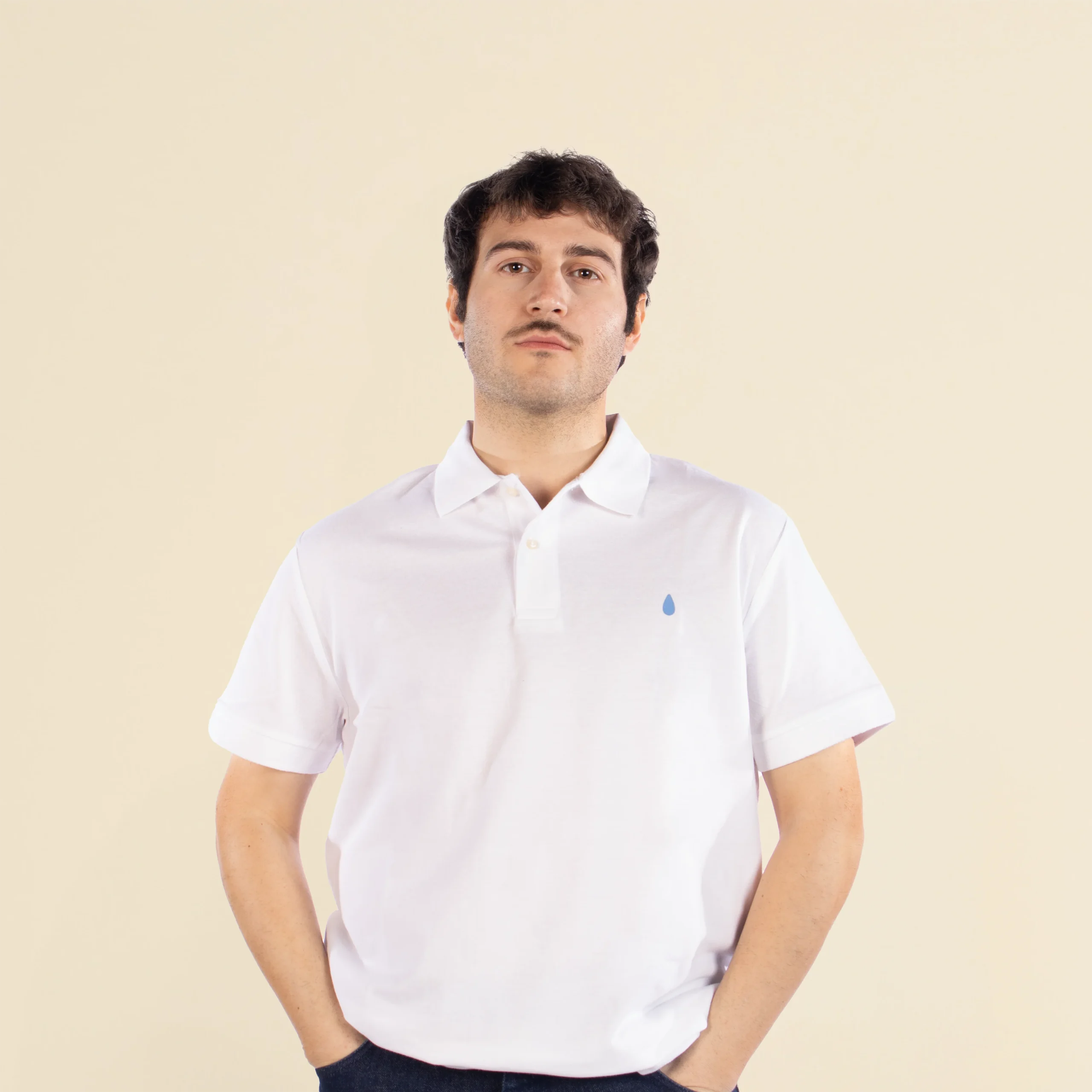Chico de frente llevando un polo blanco personalizado con una ilustración de una gota de agua azul pequeña