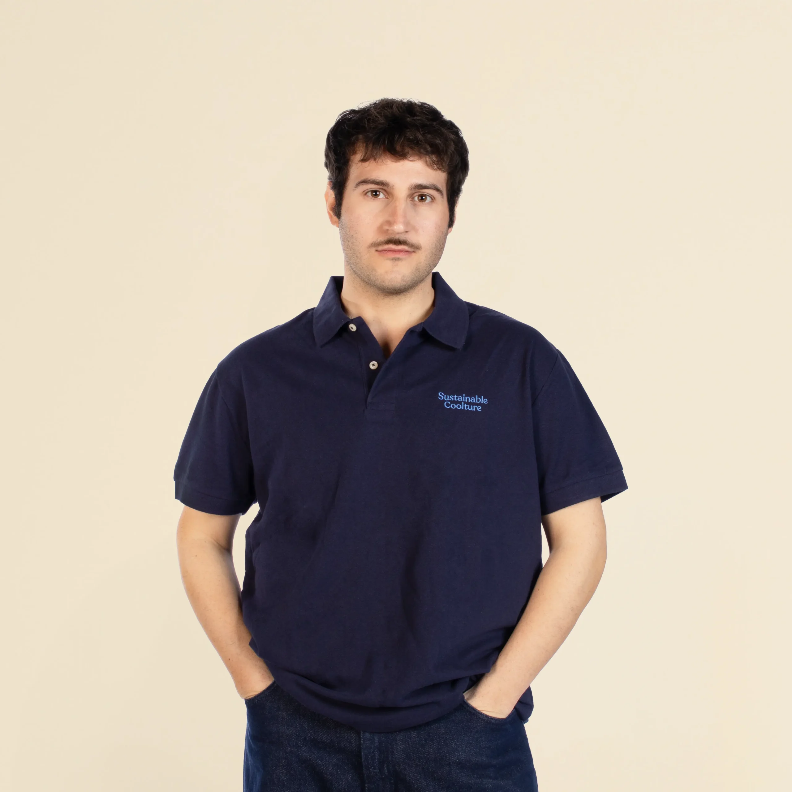 Chico de frente llevando un polo azul personalizado con el texto "sustainable coolture"