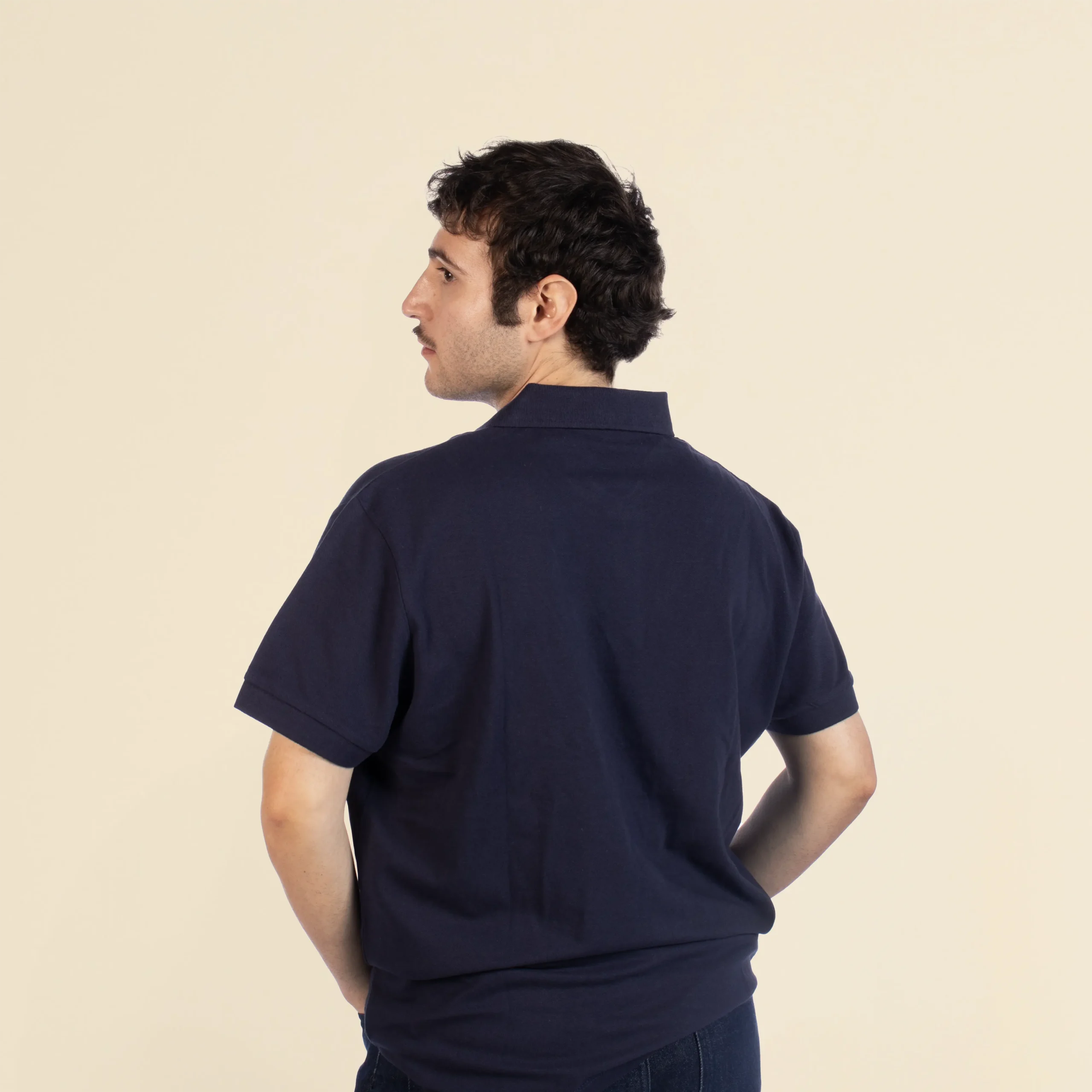 Chico de espaldas llevando con un polo azul marino