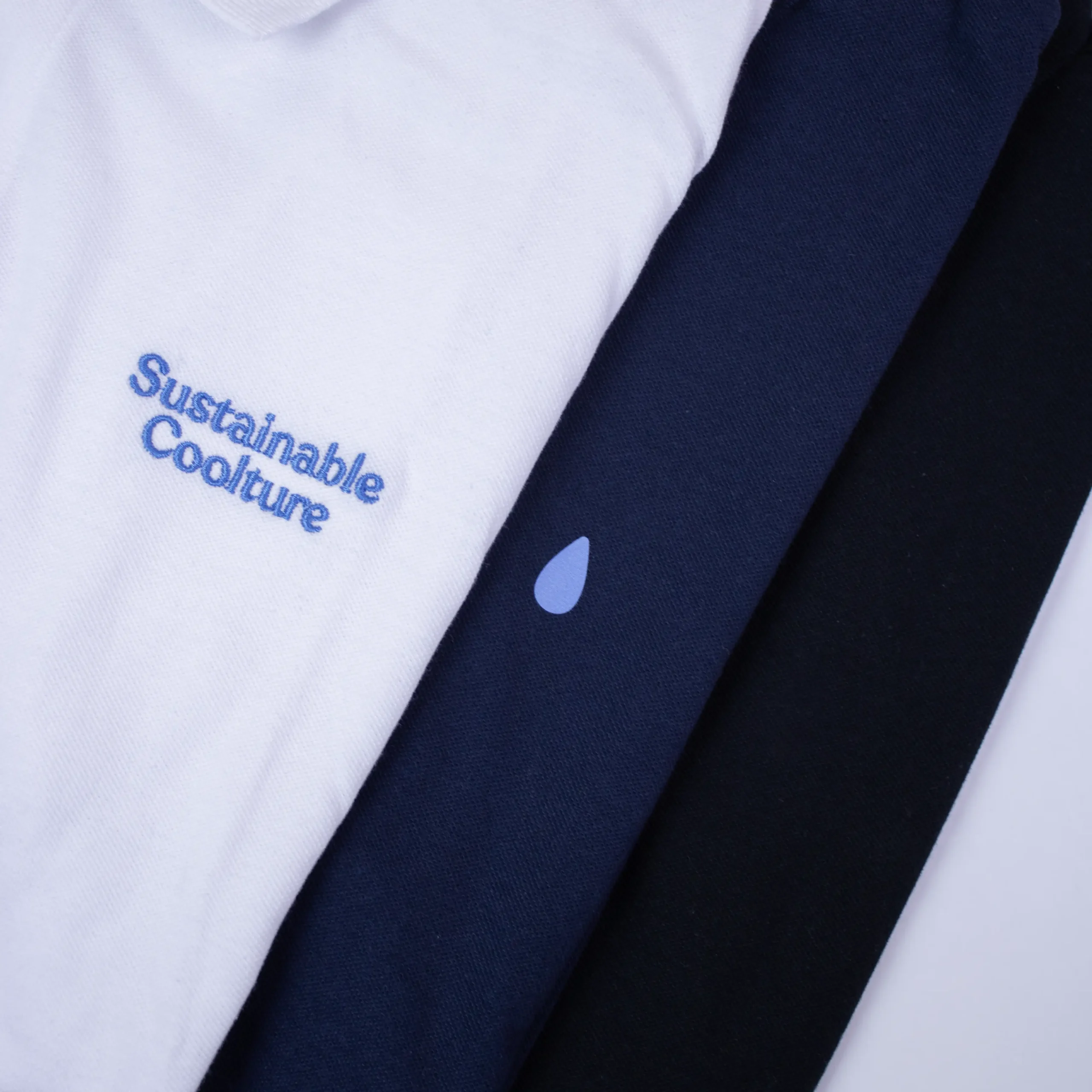 Polos de colores superpuestos con detalle de la personalización del texto "sustainable coolture" en bordado