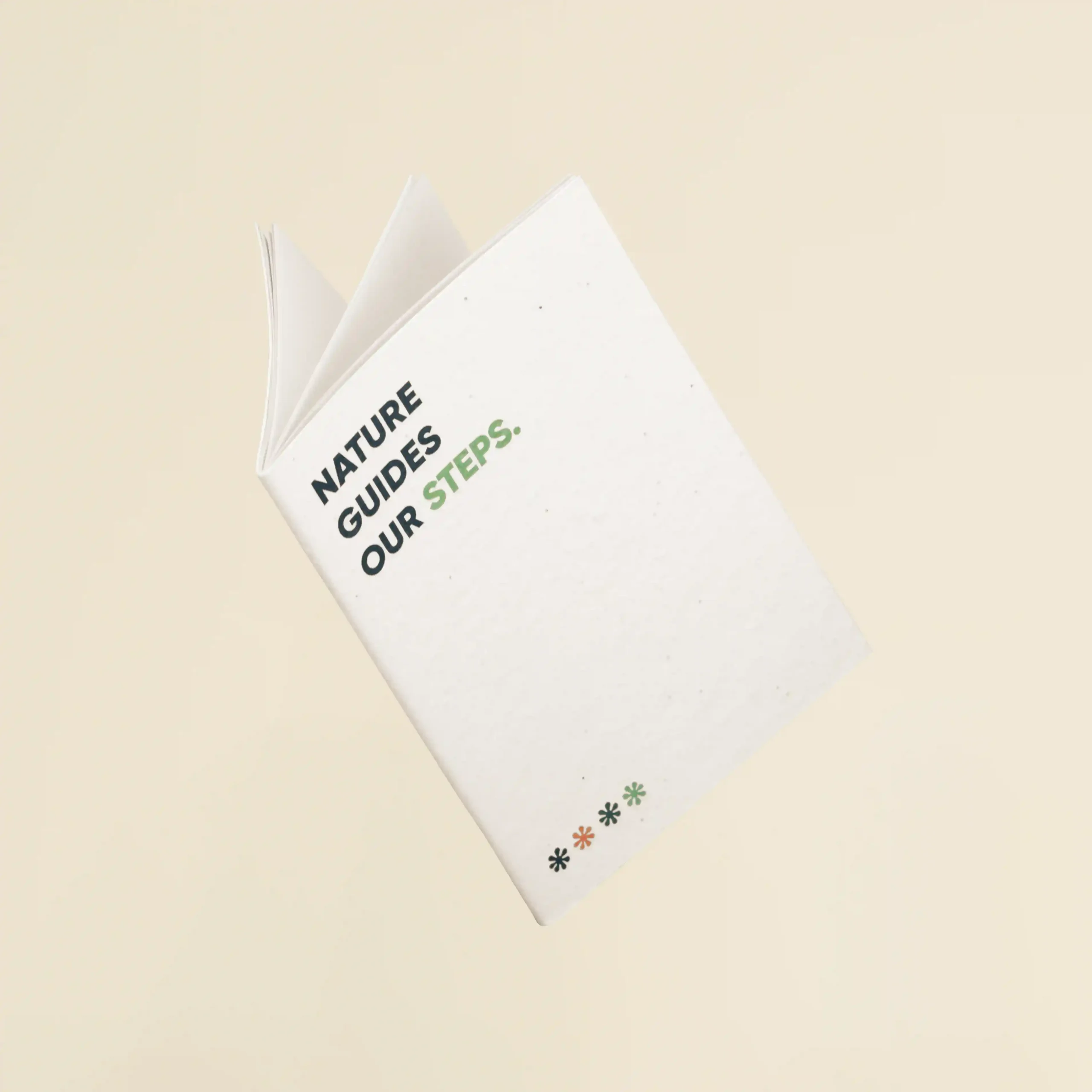Cuaderno plantable blanco personalizado con el texto 'Nature guides our steps'