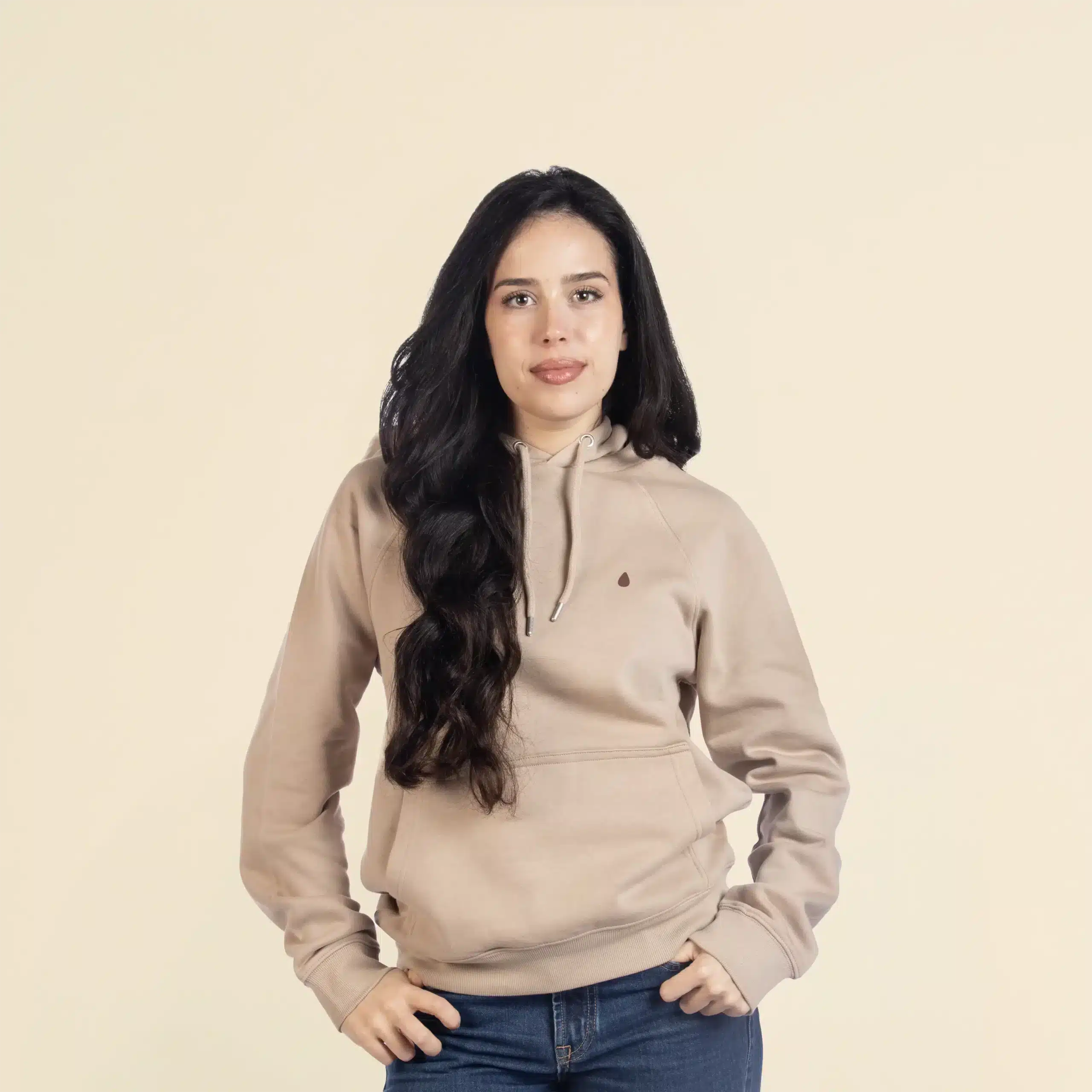 Chica morena de frente llevando jeans y una sudadera con capucha beige personalizada