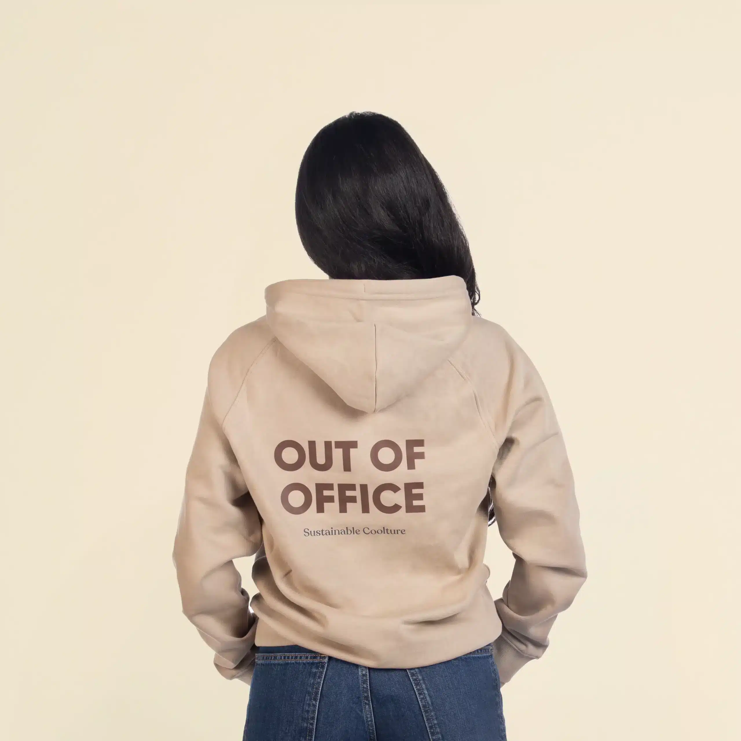 Chica morena de espaldas llevando jeans y una sudadera con capucha beige personalizada