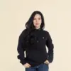 Chica morena de frente llevando jeans y una sudadera con capucha negra personalizada