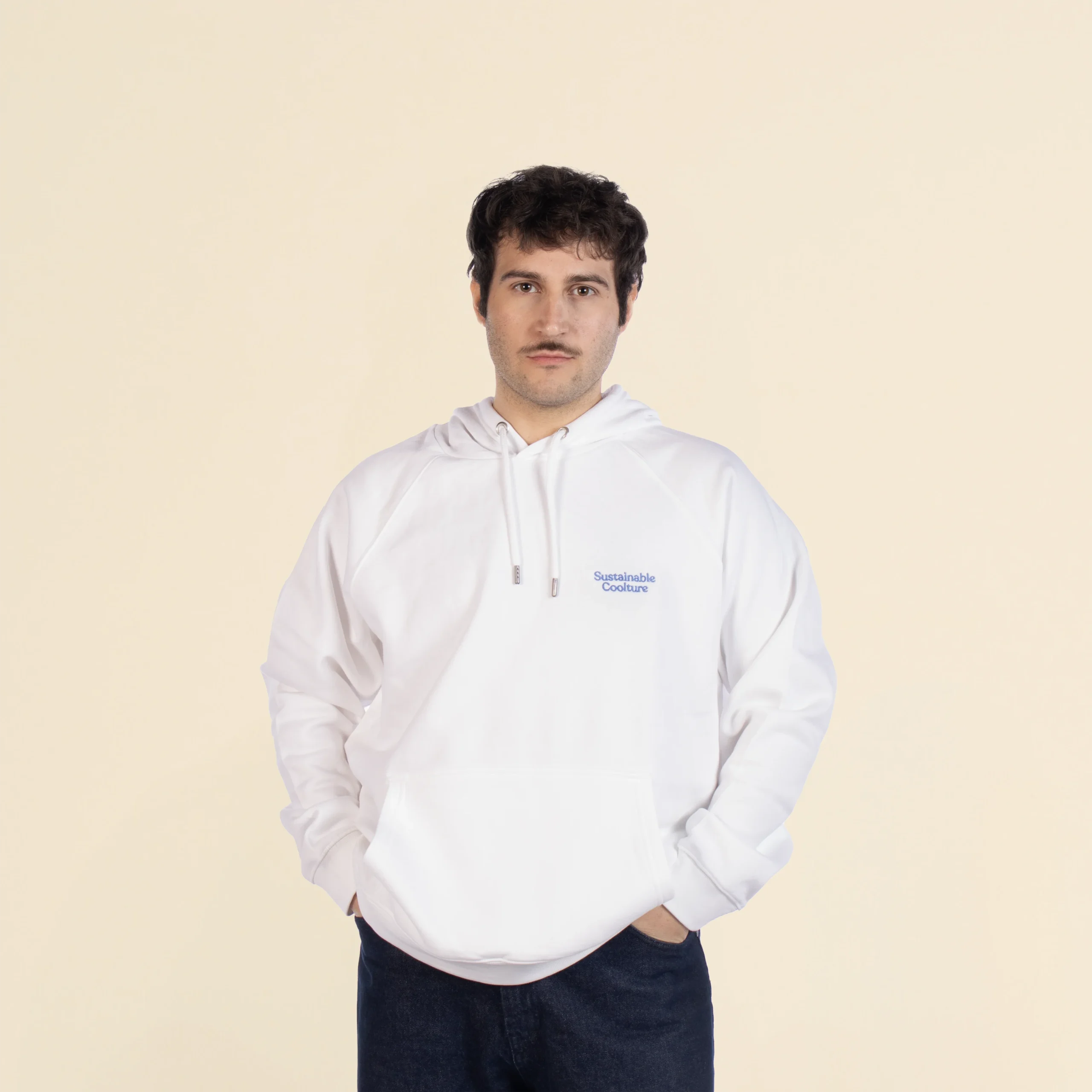 Chico moreno de frente llevando jeans y una sudadera blanca con capucha personalizada