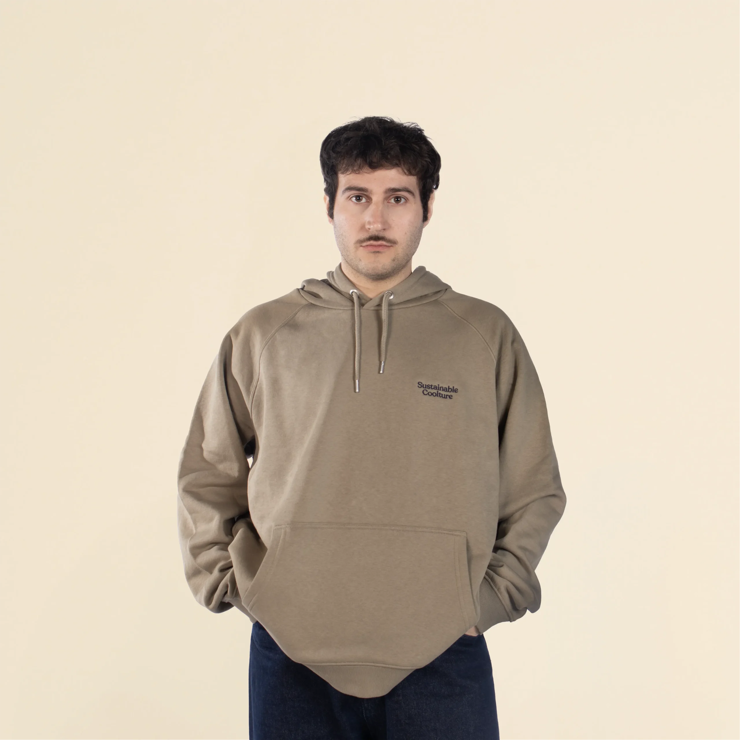 Chico moreno de frente llevando jeans y una sudadera verde con capucha personalizada