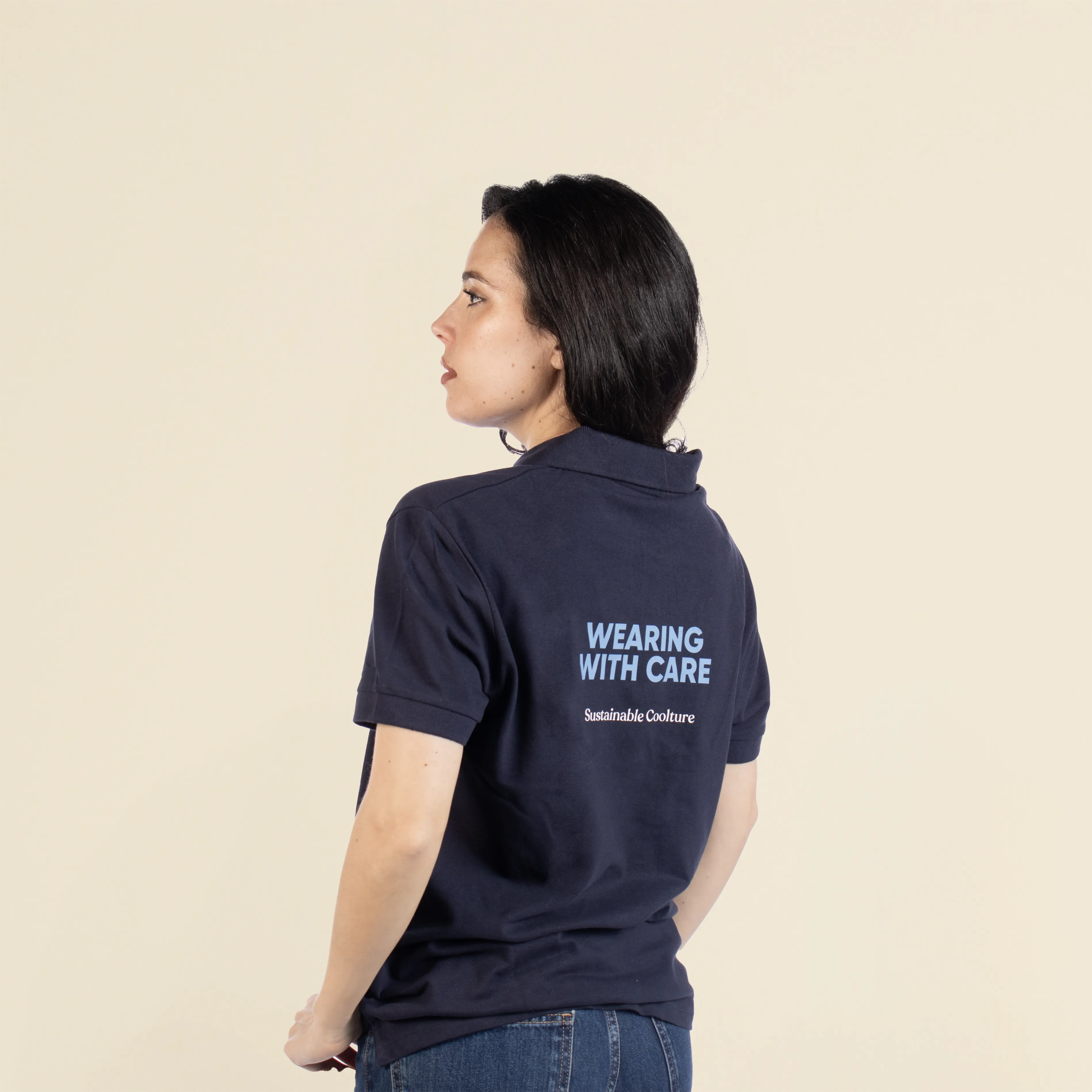Chica de espaldas llevando con un polo azul personalizado con el texto "Wearing with care"