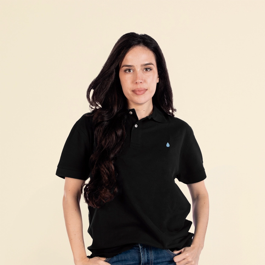 Chica de frente llevando un polo negro personalizado con una ilustración de una gota de agua azul pequeña