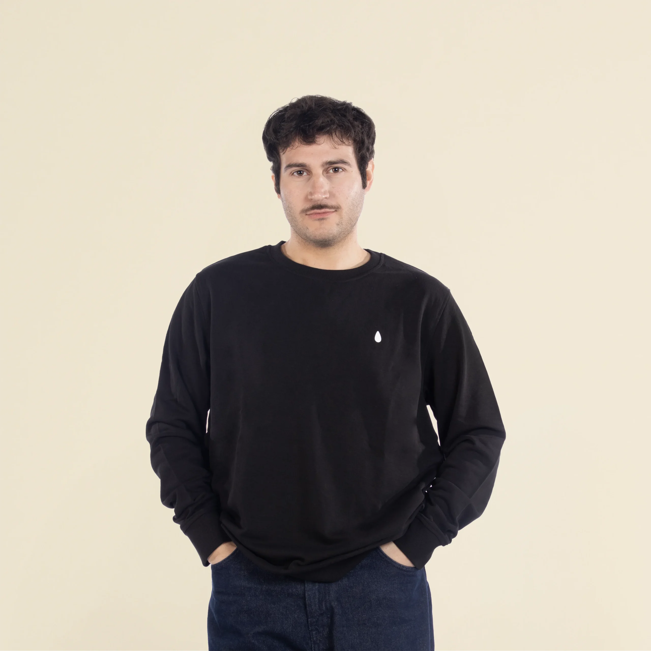 Chico moreno de frente llevando jeans y una sudadera negra personalizada