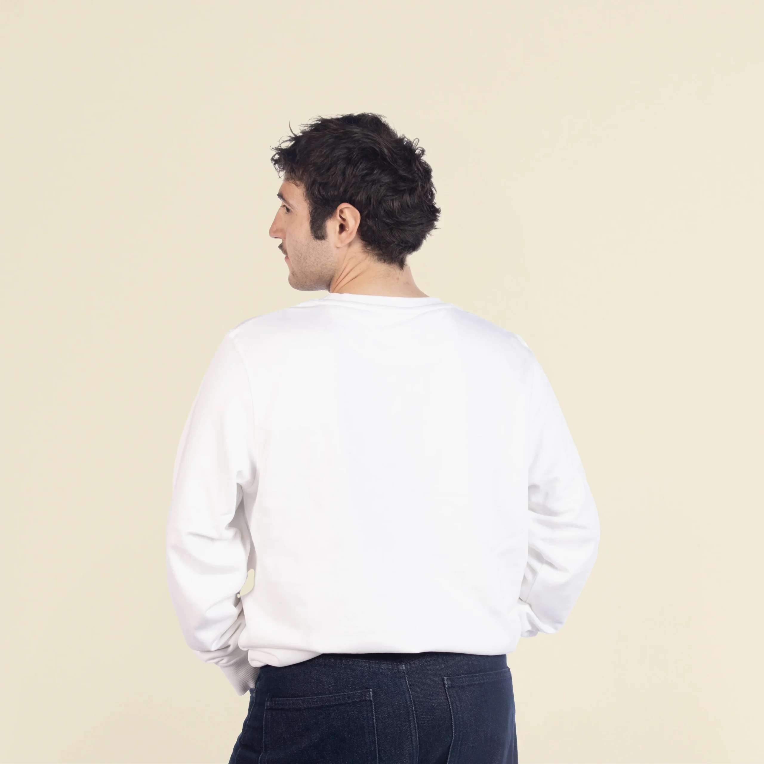 Sudadera personalizada SEDRA Blanco Chico moreno de espaldas llevando jeans y una sudadera blanca personalizada