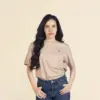Chica morena de frente llevando jeans y una camiseta beige personalizada