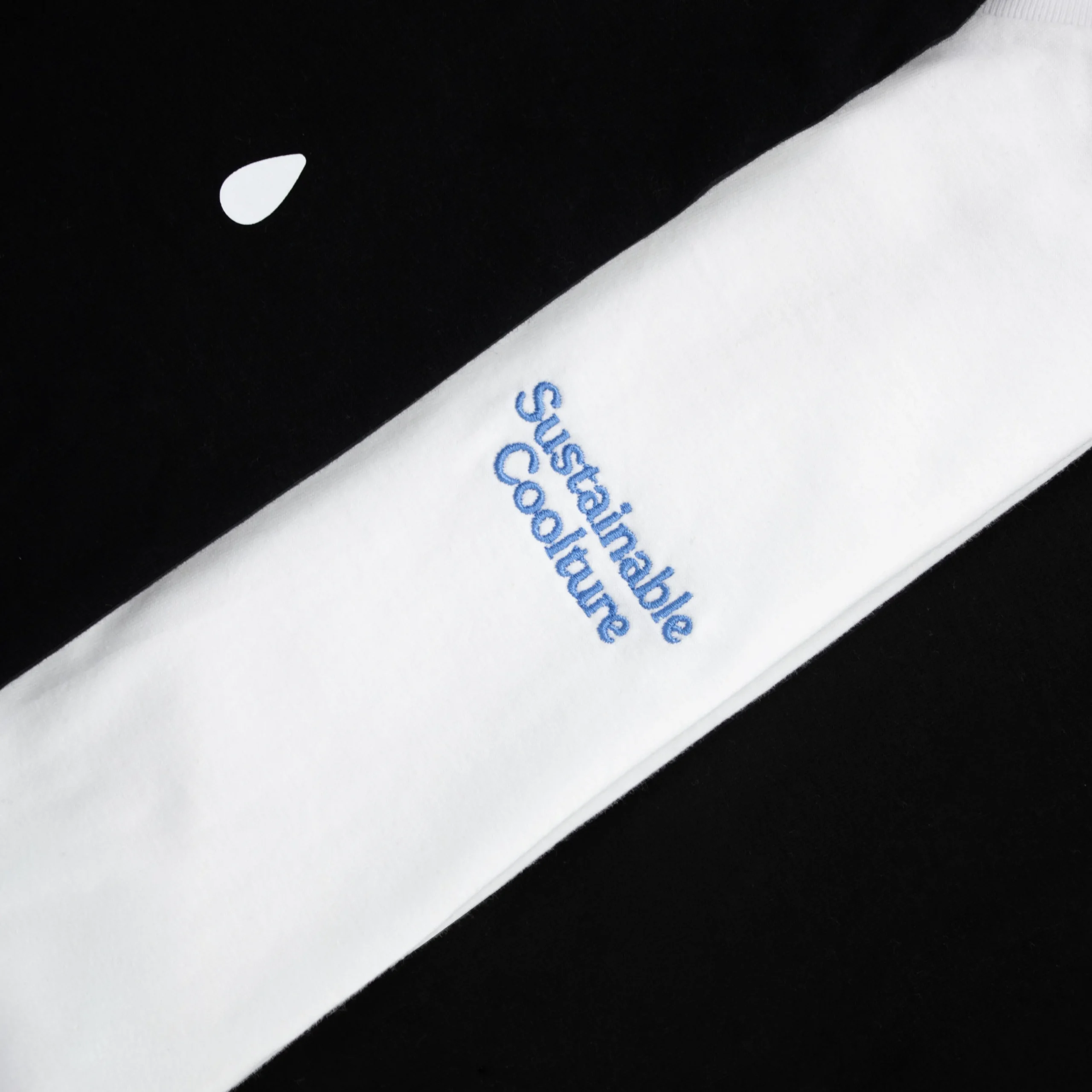 Detalle del texto 'sustainable coolture' bordado en una camiseta blanca