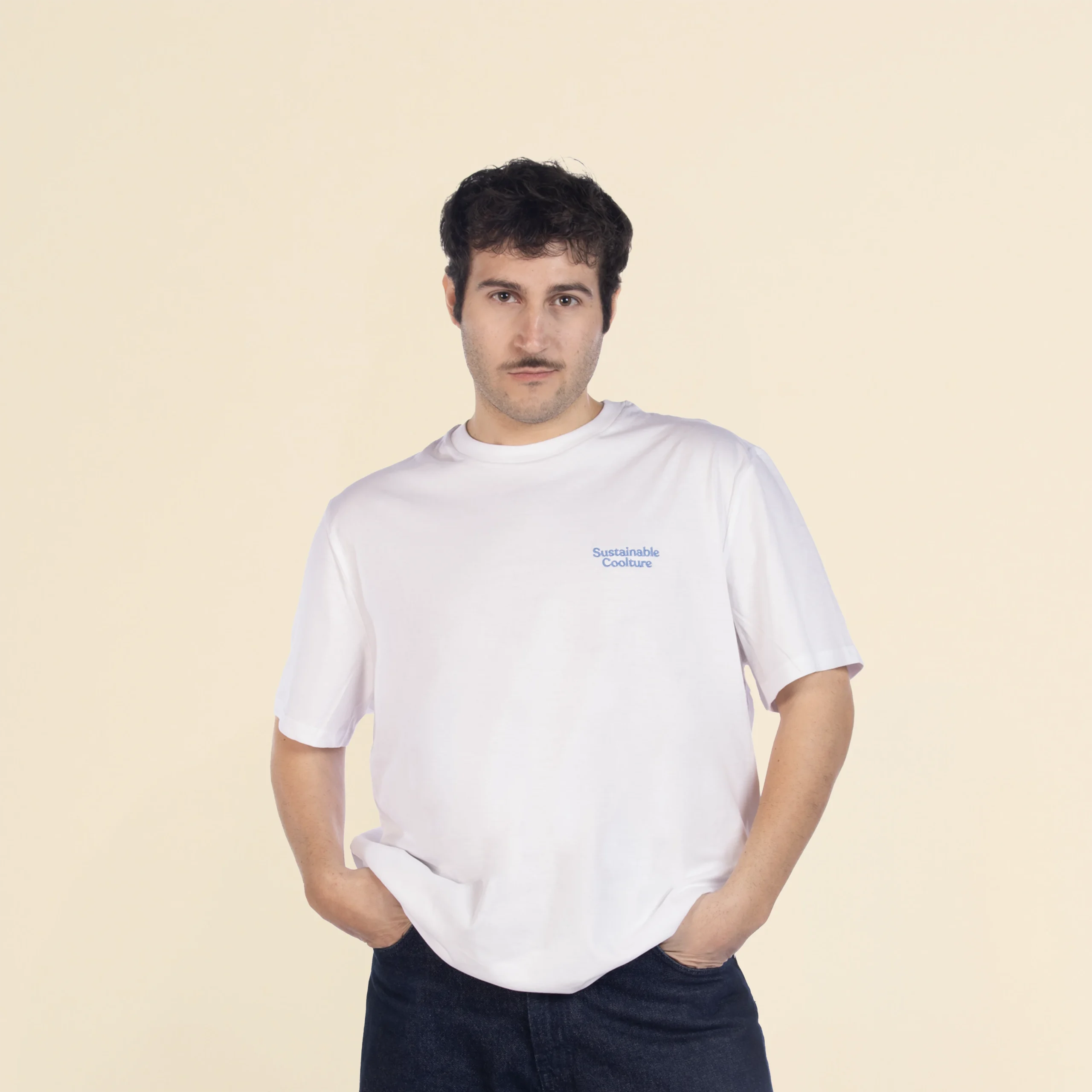 Chico moreno de frente llevando jeans y una camiseta blanca personalizada