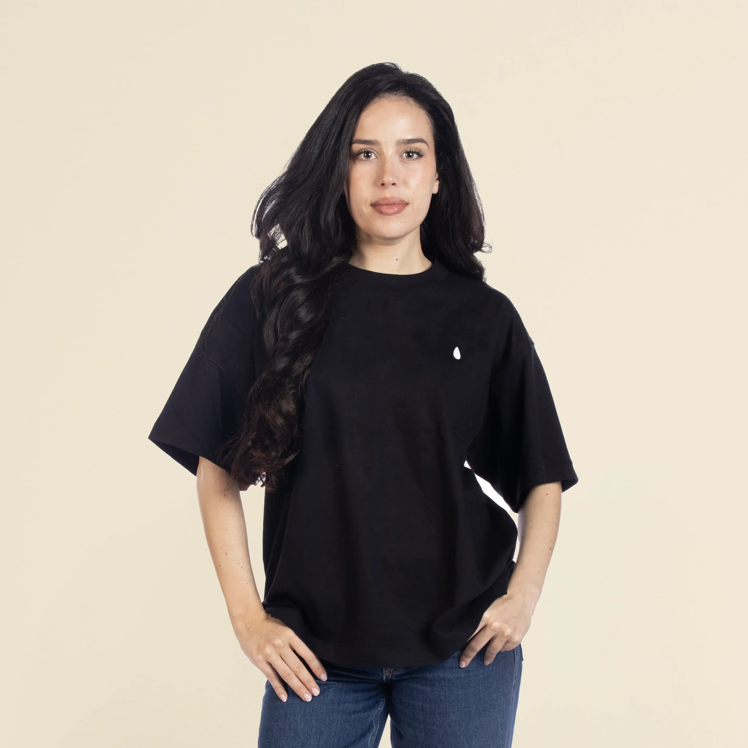 Chica morena de frente llevando jeans y una camiseta oversize negra personalizada