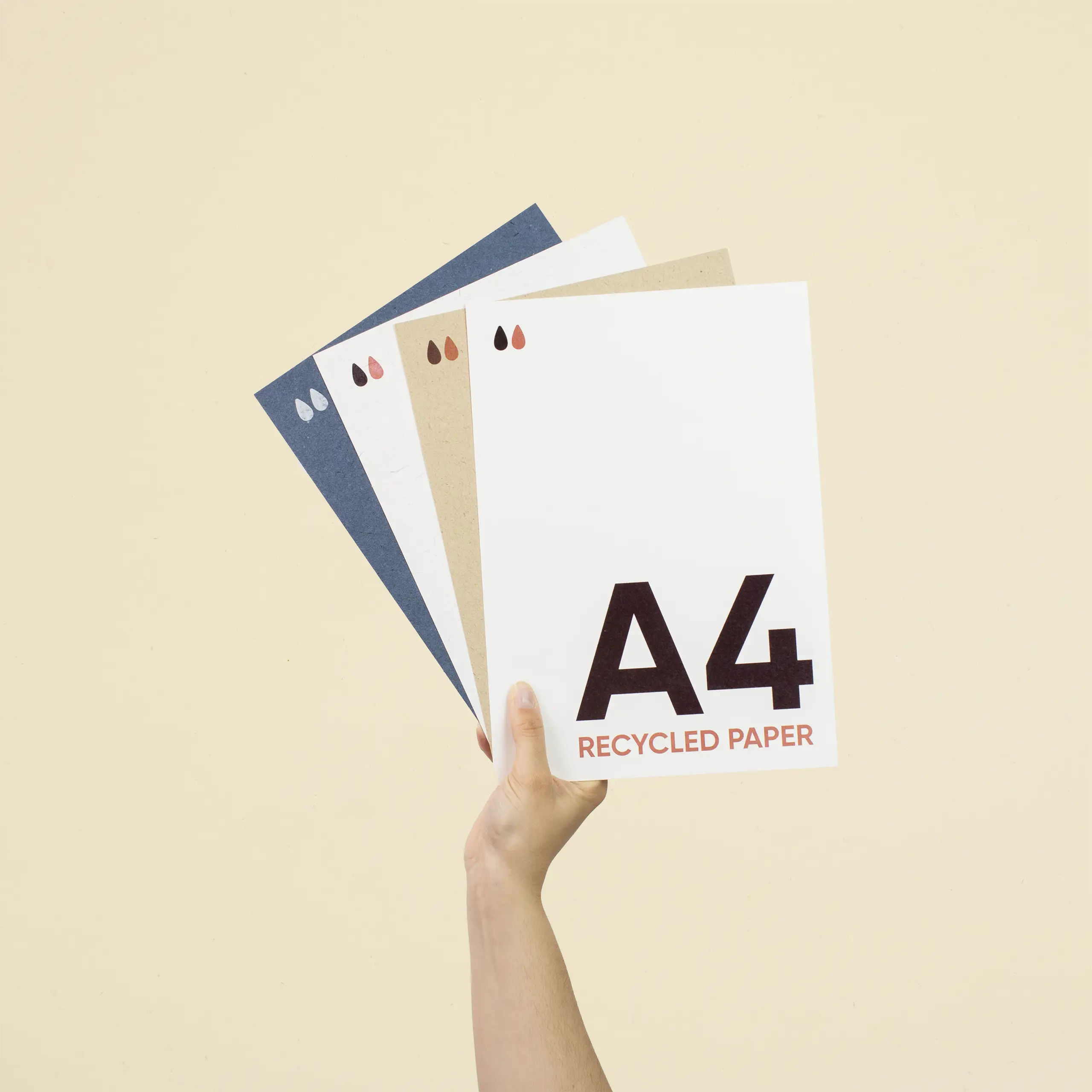 Una mano sujetando cuatro tarjetas A4 impresas en papel ecológico
