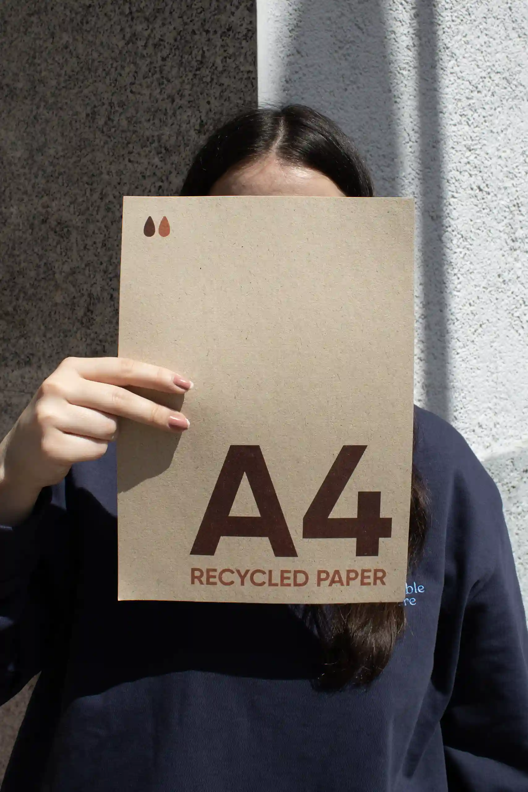 Chica mostrando a cámara una tarjeta A4 impresa en papel ecológico
