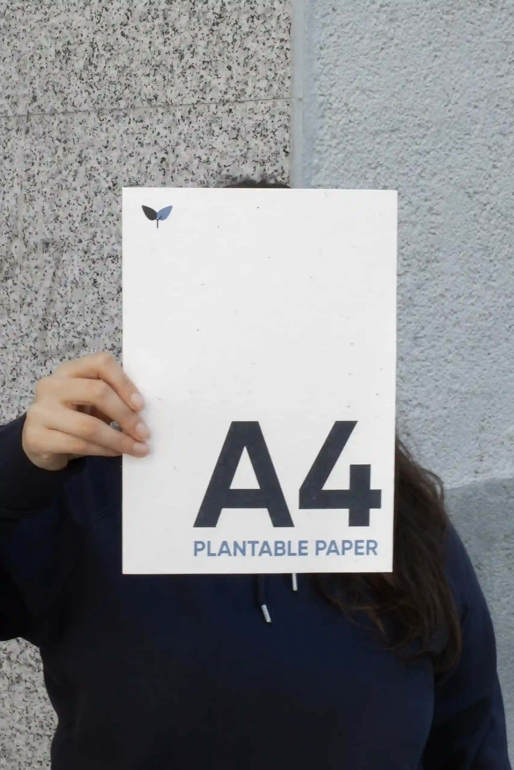 Chica mostrando a cámara una hoja A4 impresa en papel plantable