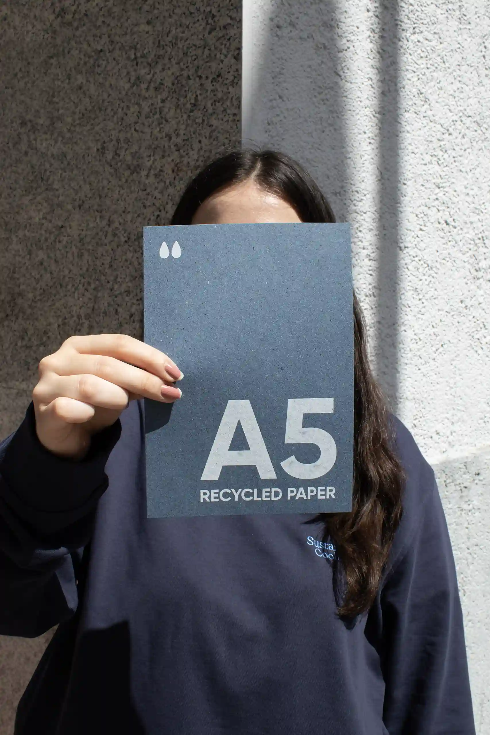 Chica mostrando a cámara una tarjeta A5 impresa en papel ecológico