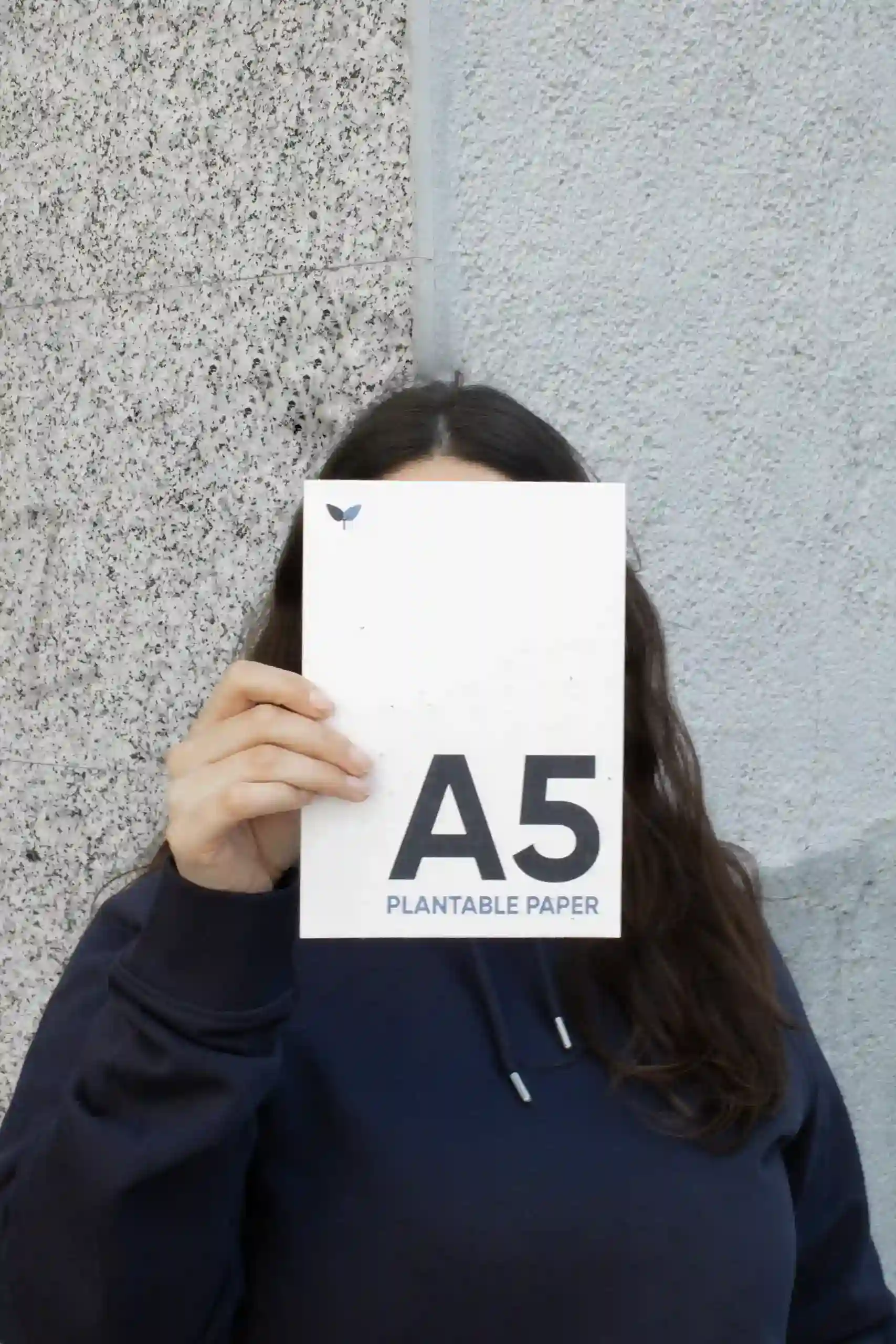 Chica mostrando a cámara una tarjeta A5 impresa en papel plantable