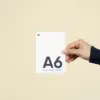 Mano mostrando una tarjeta A6 impresa en papel plantable