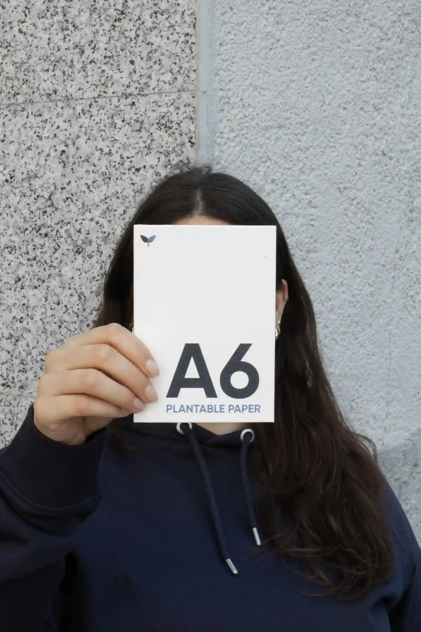 Chica mostrando a cámara una tarjeta A6 impresa en papel plantable