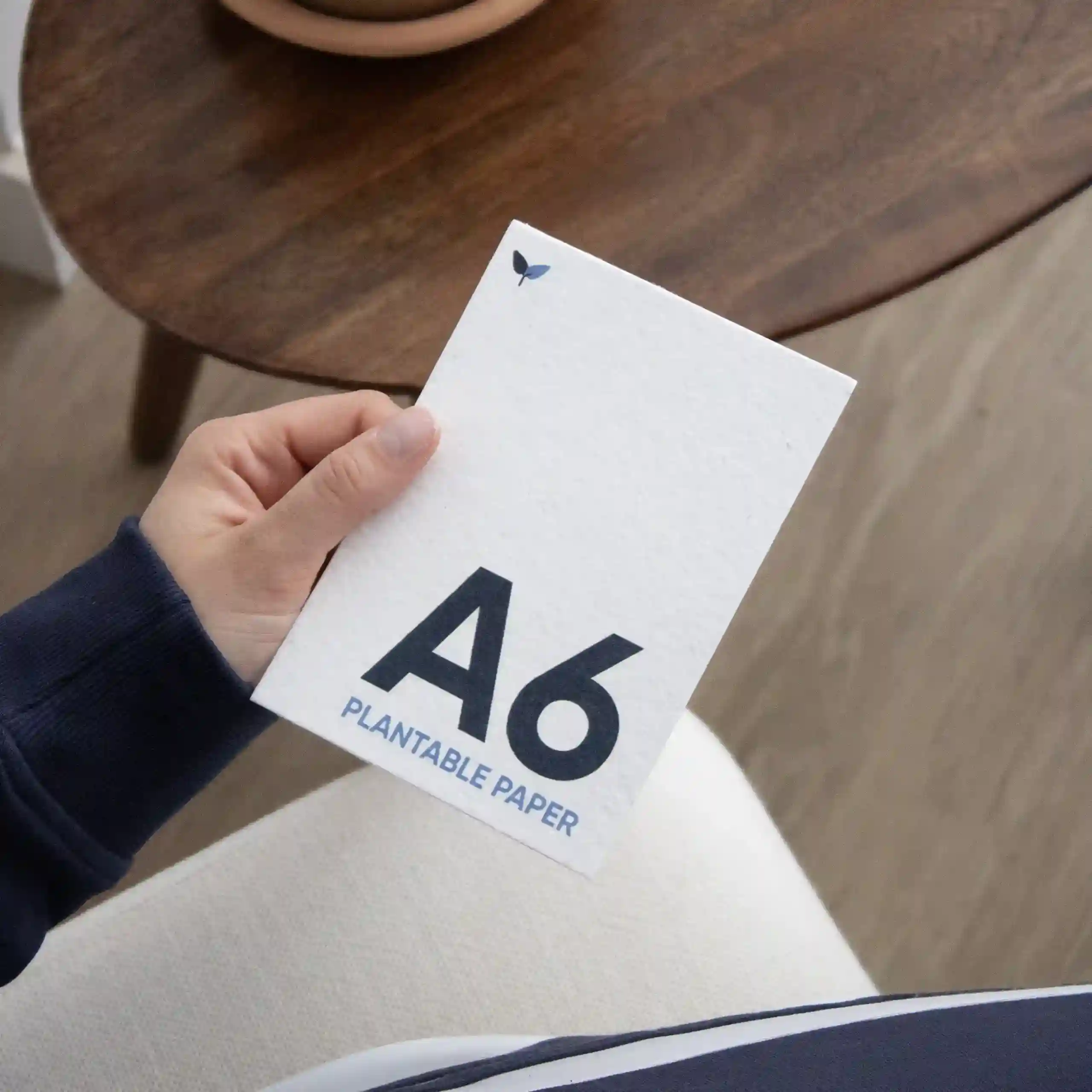 Una mano sujetando una tarjeta A6 impresa en papel plantable