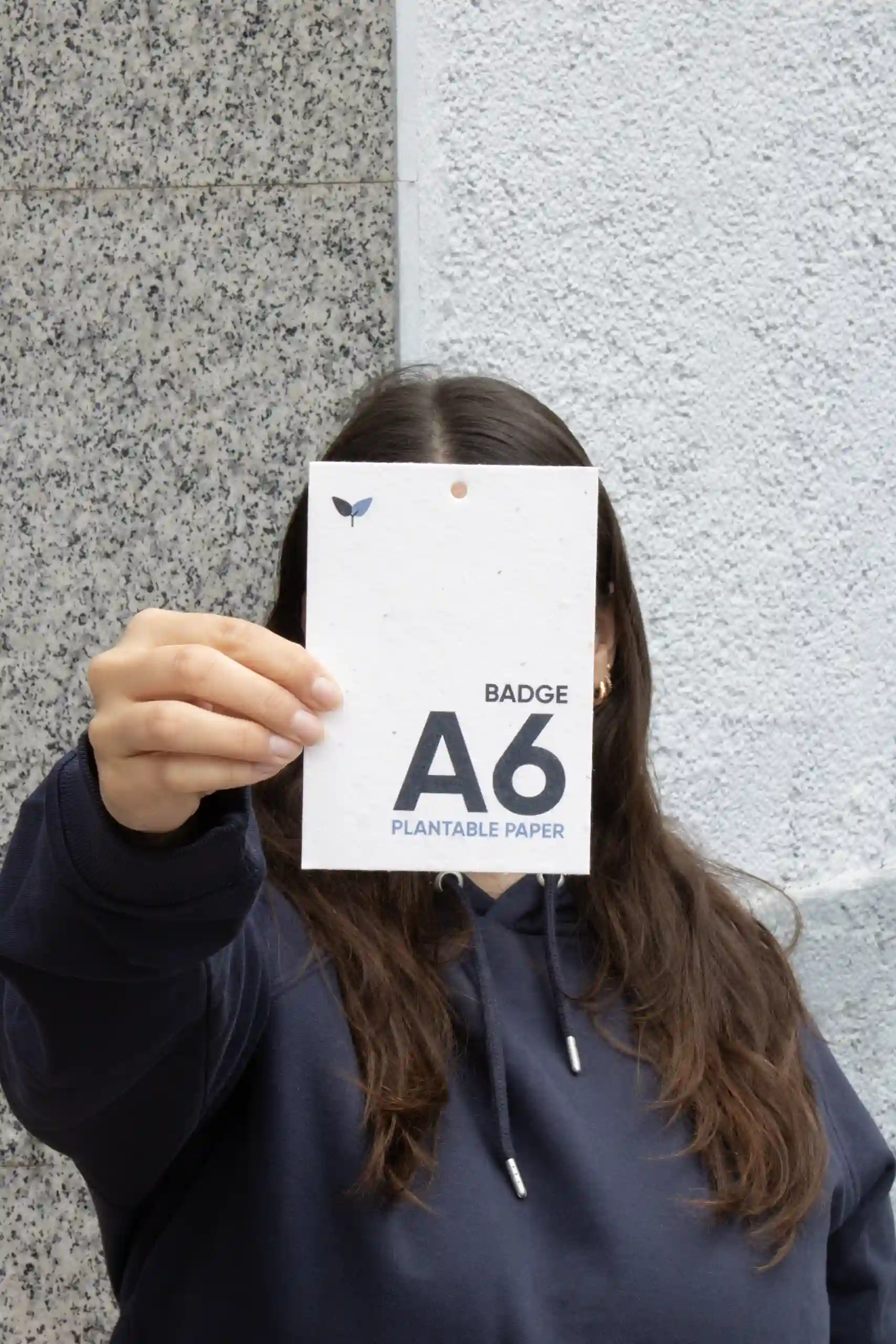 Chica mostrando a cámara una acreditación plantable A6 impresa en papel plantable