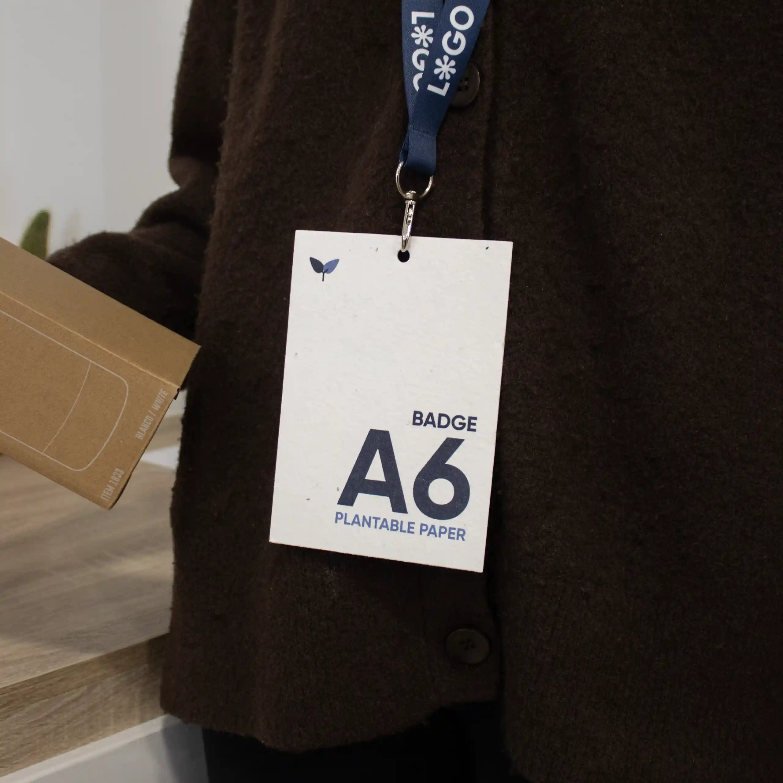 Acreditación A6 impresa en papel plantable con lanyard colgada del cuello de una persona