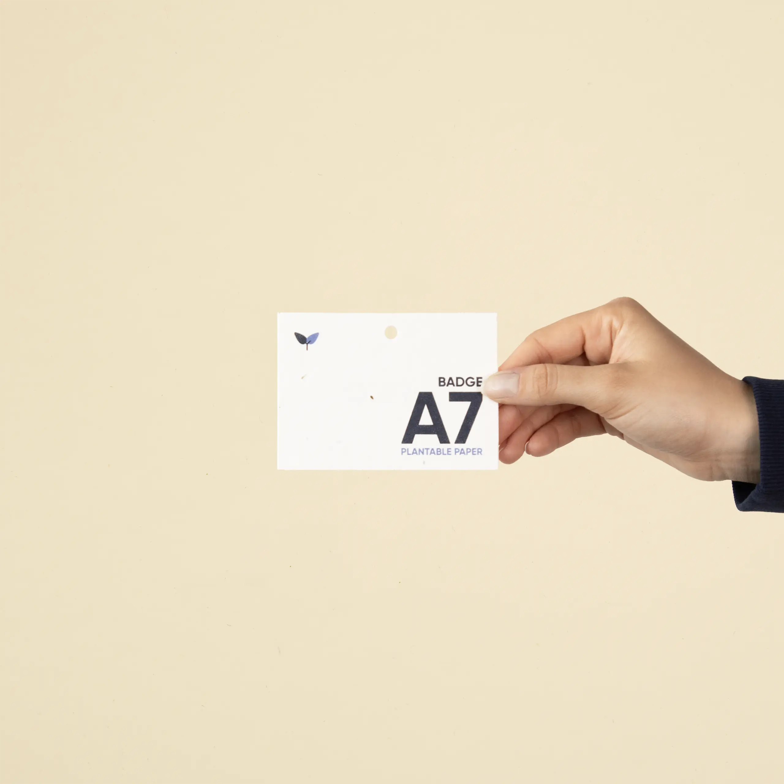 Mano mostrando una acreditación A7 impresa en papel plantable