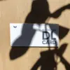 Tarjeta DL impresa en papel plantable sobre una superficie de madera con sombras