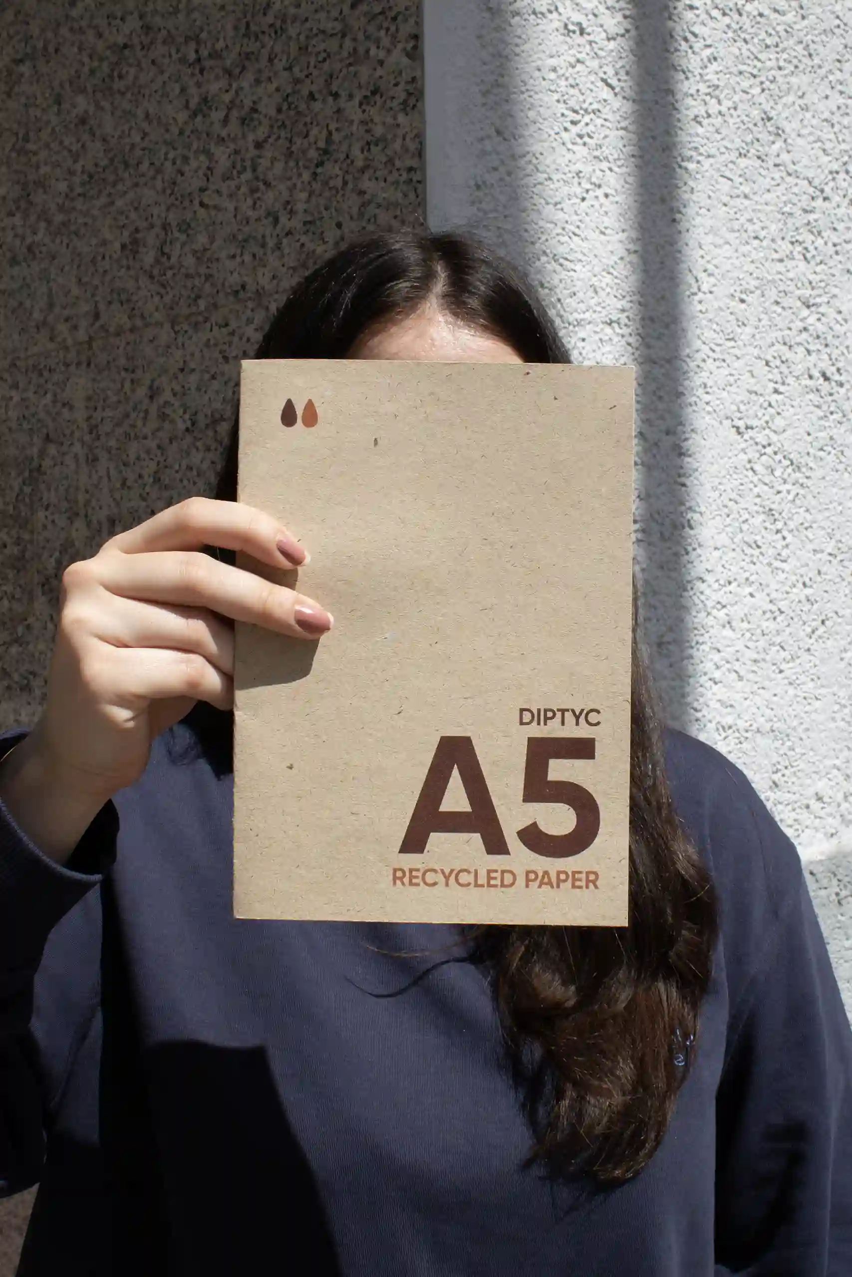 Chica mostrando a cámara un díptico A5 impreso en papel ecológico