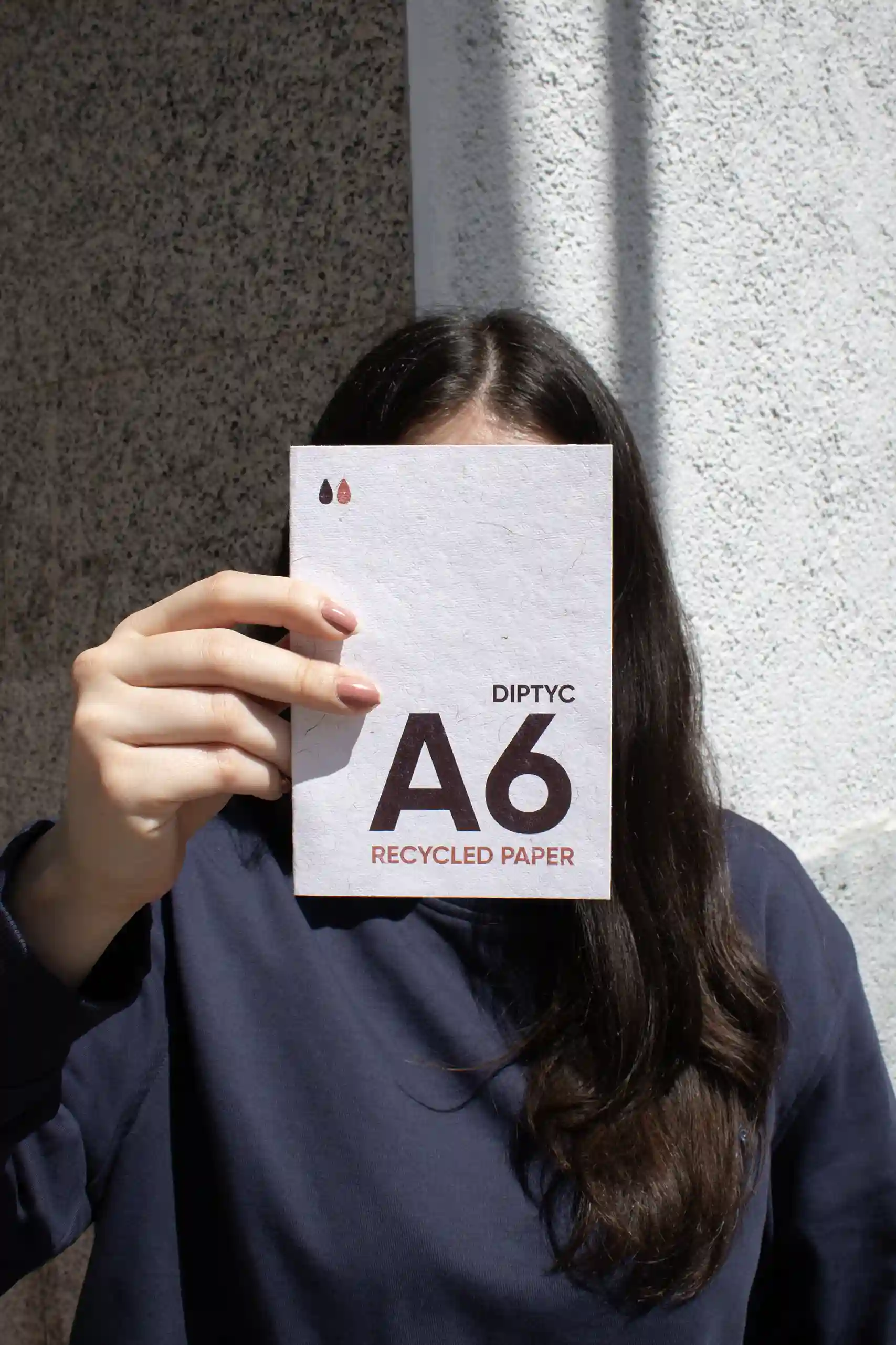 Chica mostrando a cámara un díptico A6 impreso en papel ecológico