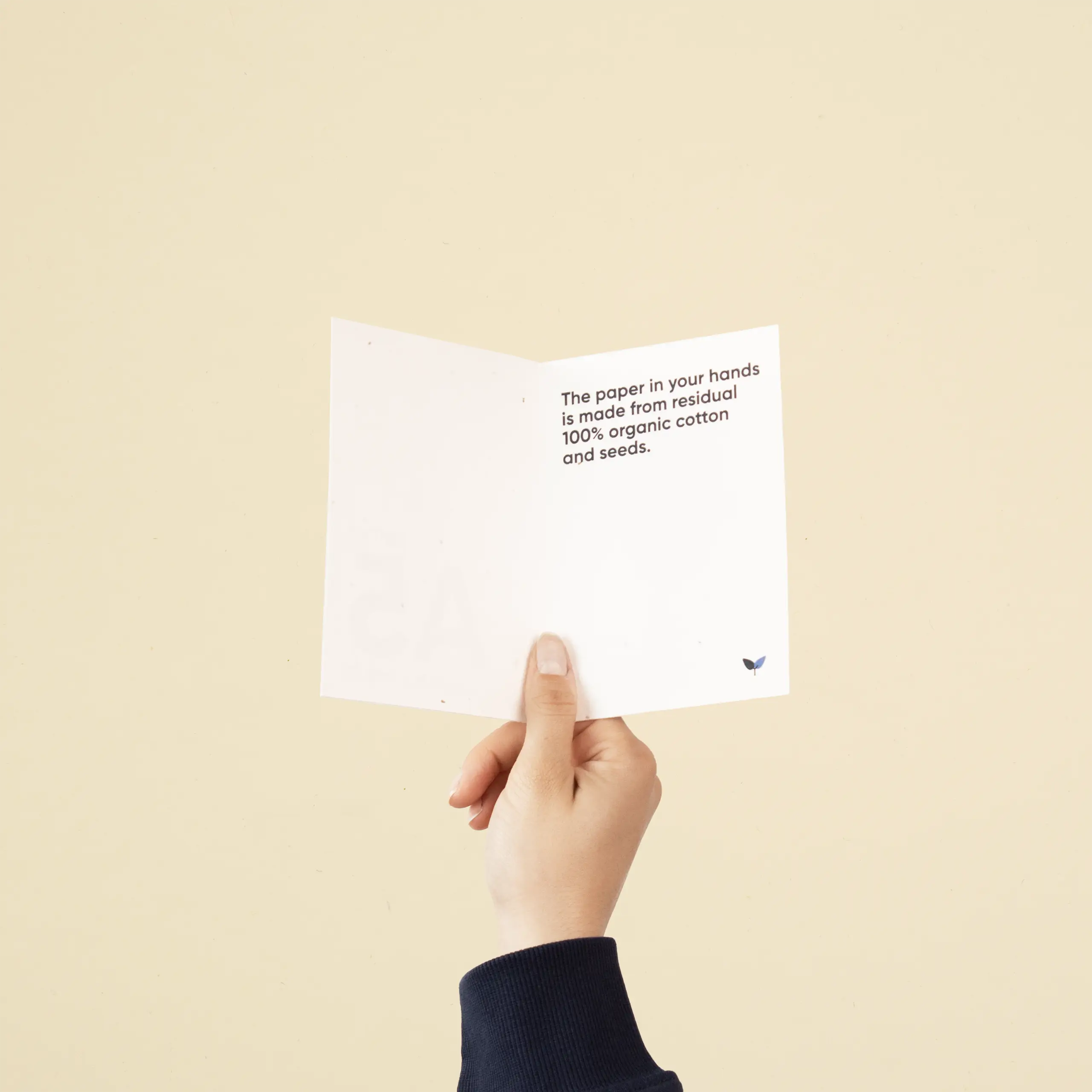 Díptico A6 plantable Mano sujetando un díptico A6 abierto impreso en papel plantable