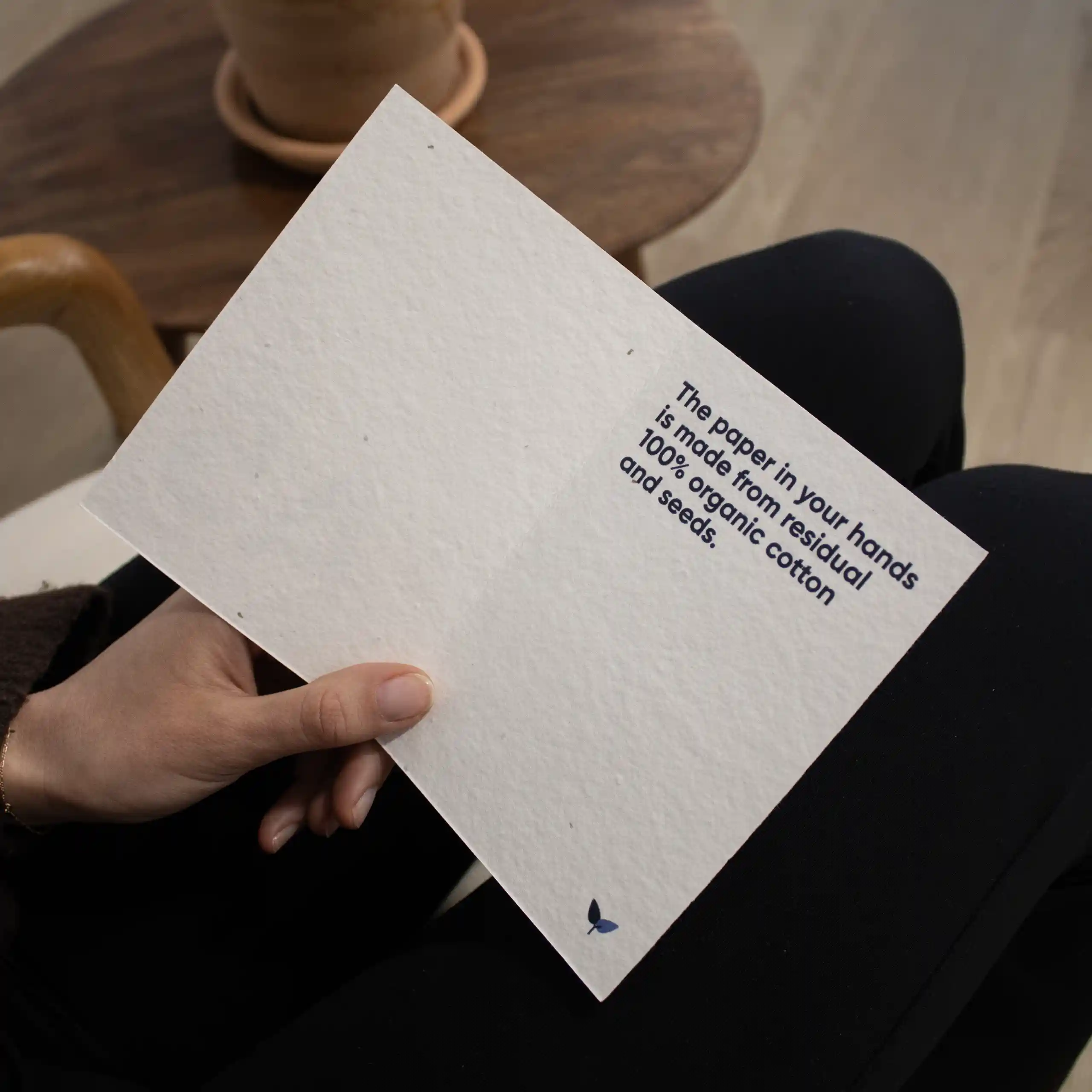 Díptico A6 plantable Mano sujetando un díptico A6 abierto impreso en papel plantable