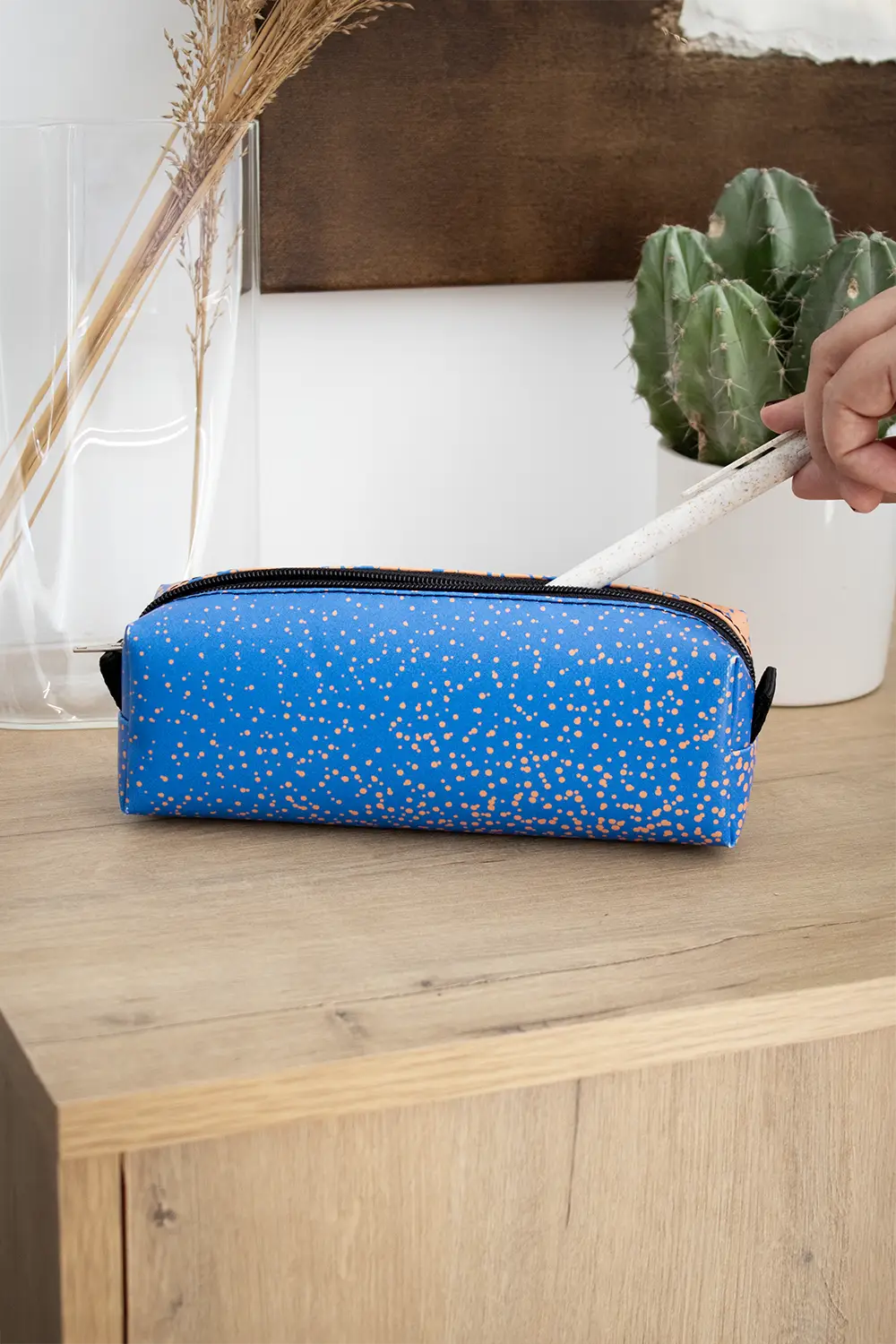 Mano metiendo un boli en un estuche de lona reciclada