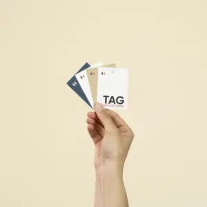 Mano sujetando cuatro etiquetas impresas en papeles ecológicos